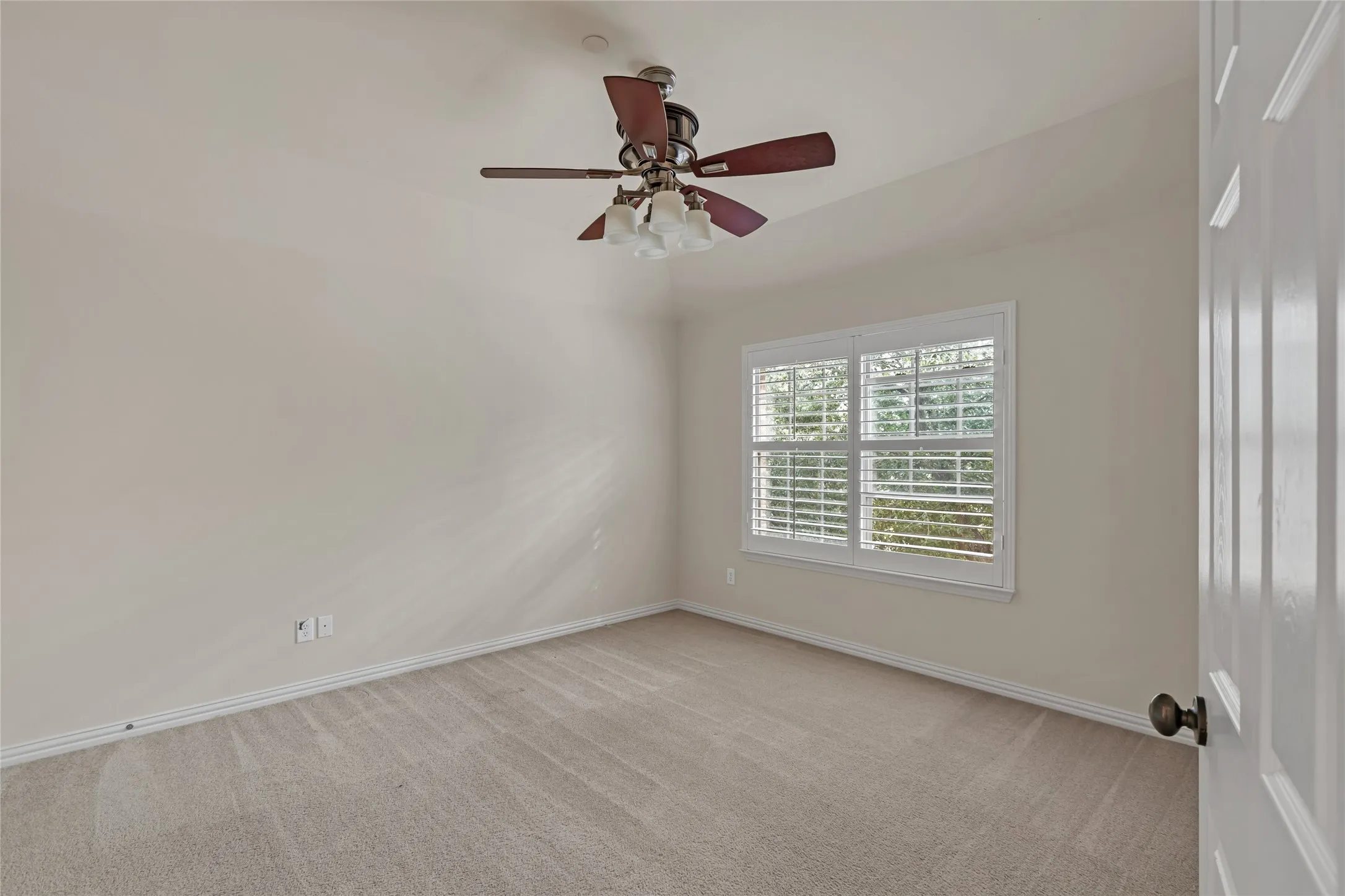 Unfurnished room featuring light colored carpet and a ceiling fan