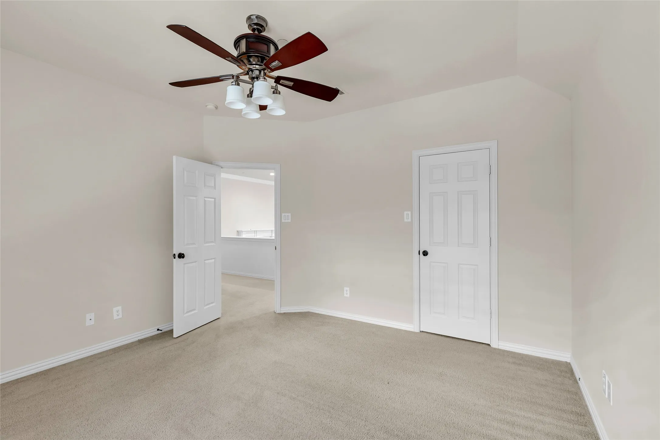 Unfurnished bedroom featuring light colored carpet and a ceiling fan