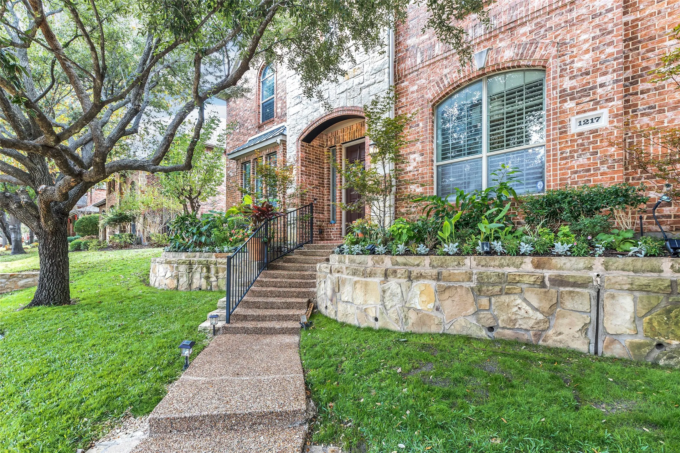 Doorway to property with brick siding and a lawn
