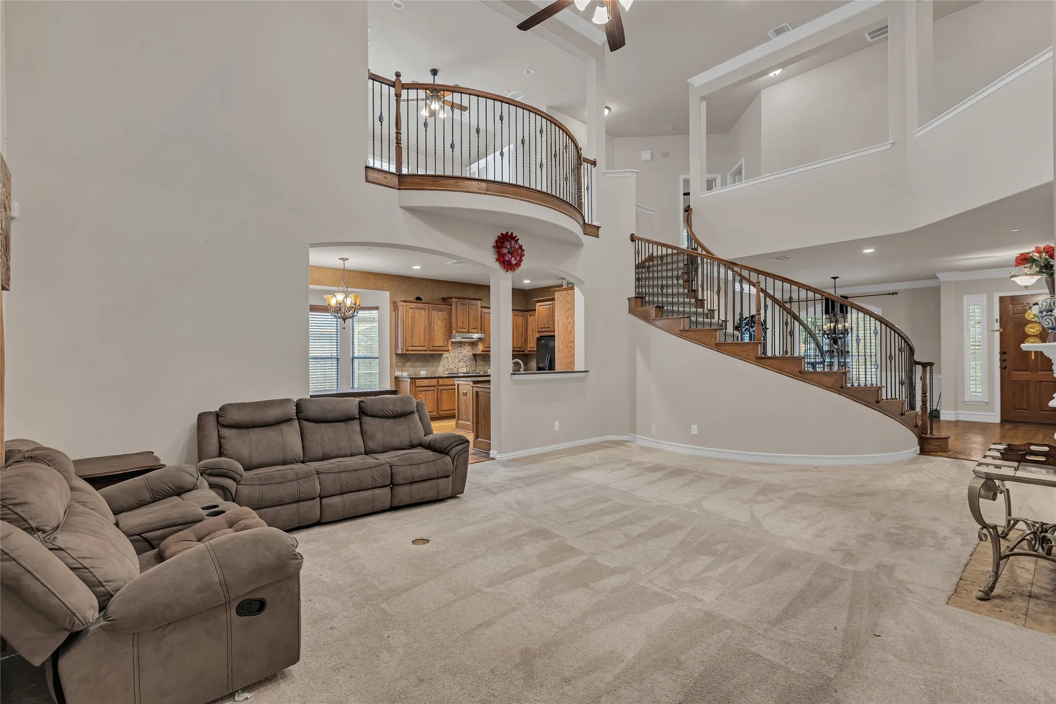 Living area featuring stairs, a chandelier, light carpet, ceiling fan, and recessed lighting