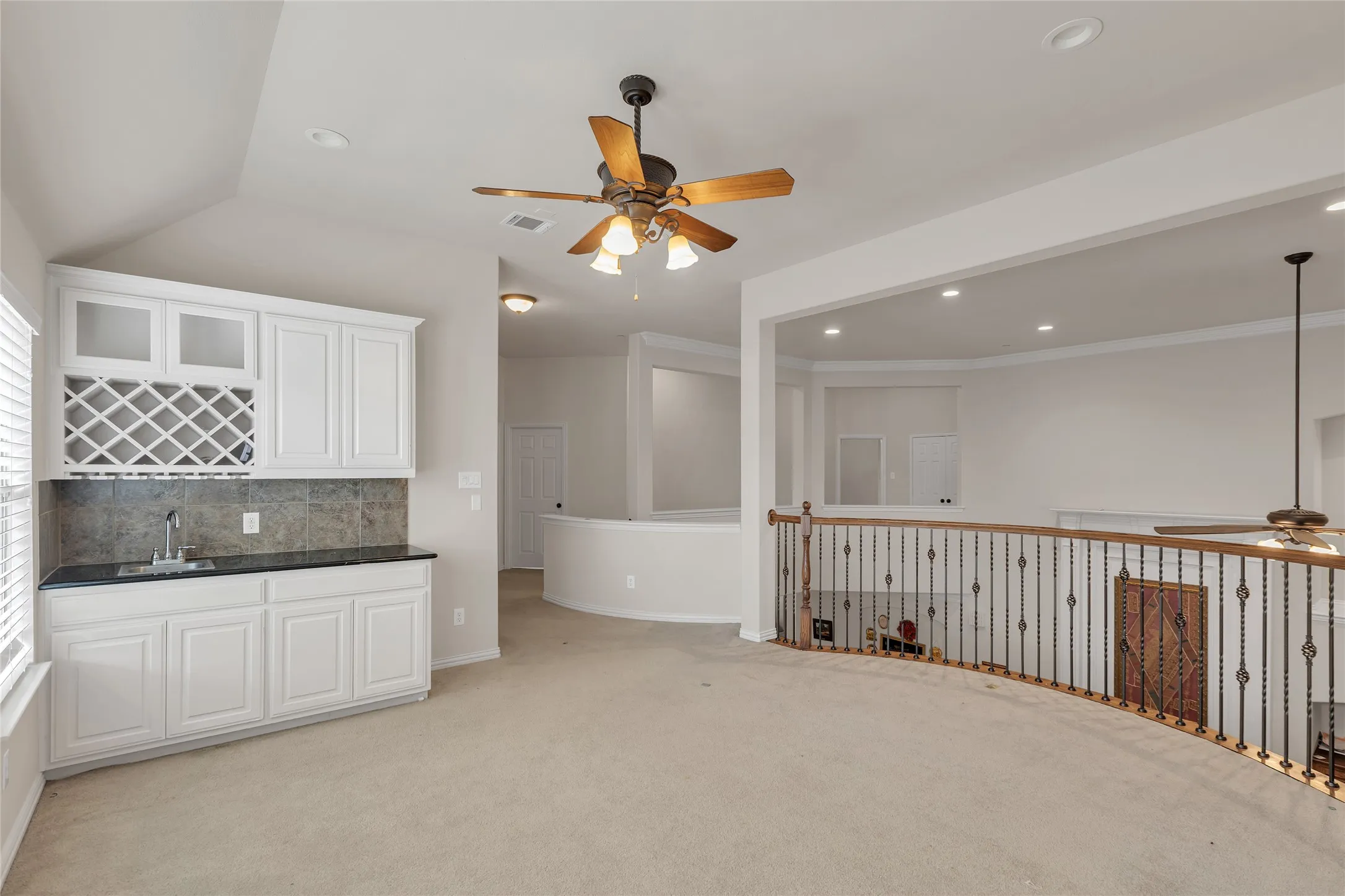 Indoor wet bar featuring a ceiling fan, backsplash, light colored carpet, white cabinets, and recessed lighting