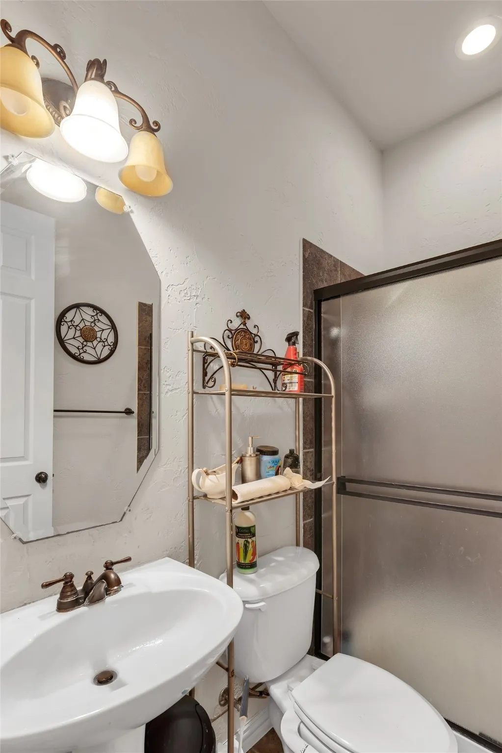 Full bathroom featuring a textured wall and a shower stall