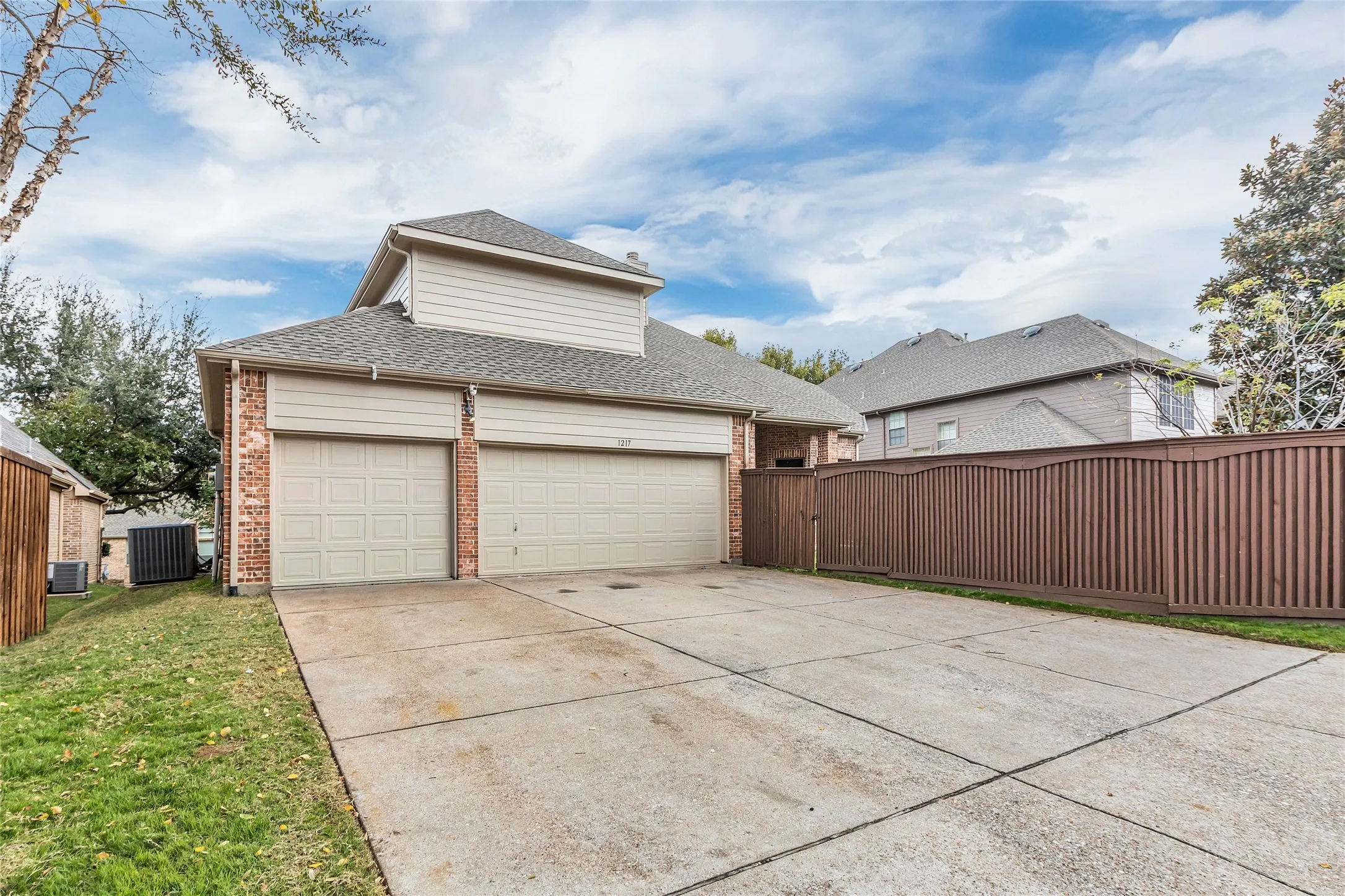 Garage featuring driveway and a gate
