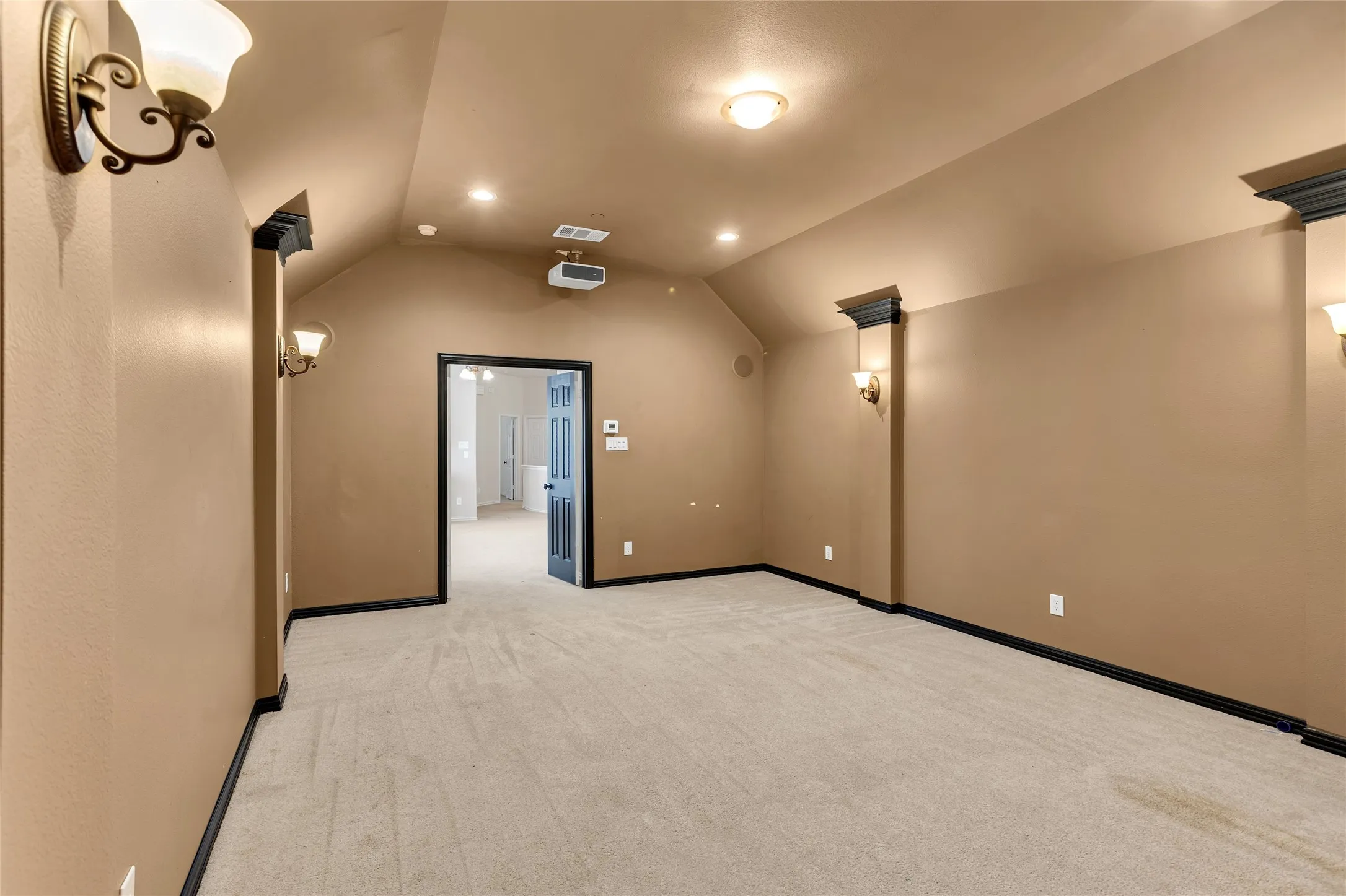 Home theater with light colored carpet, recessed lighting, and lofted ceiling