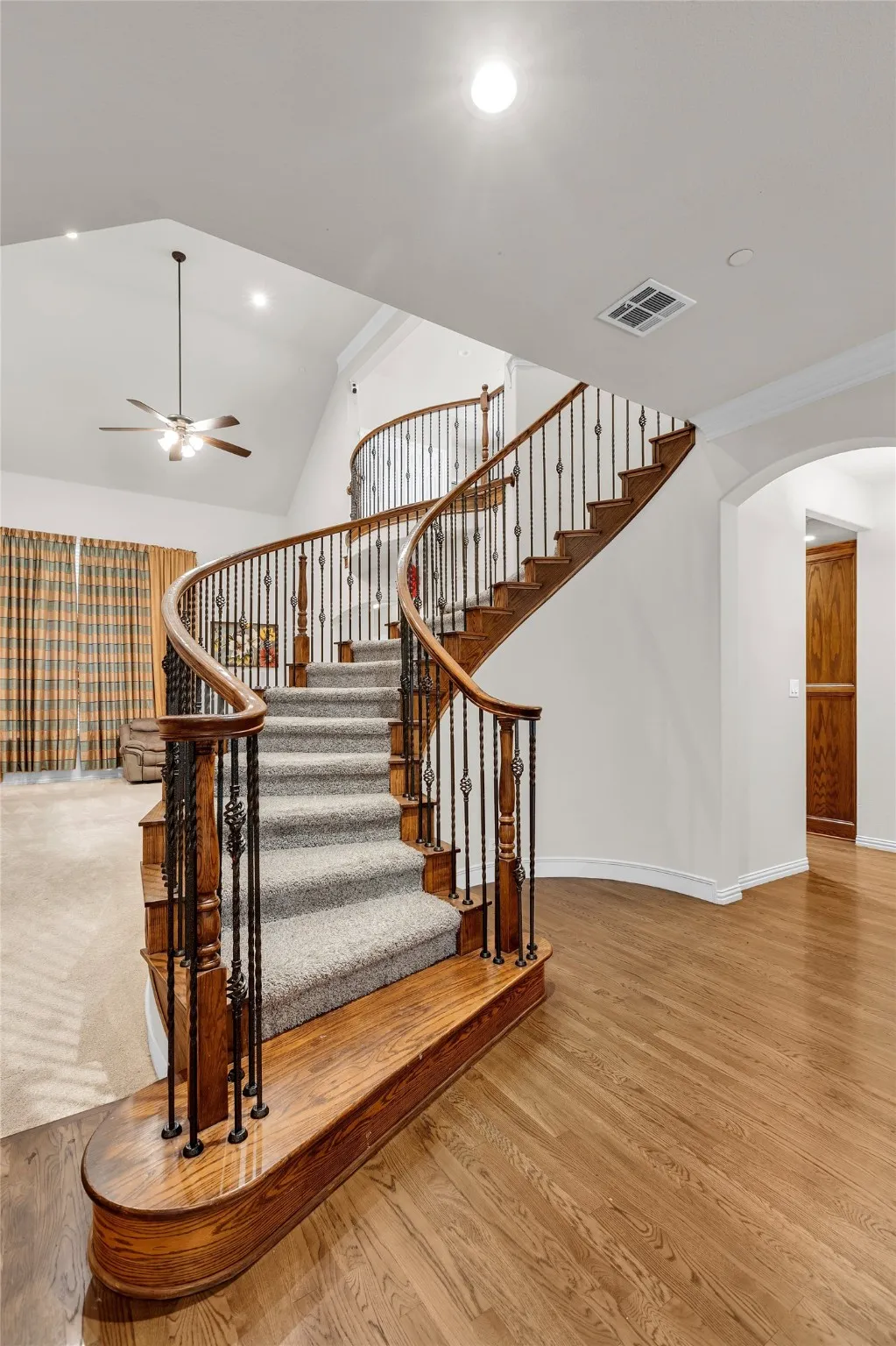 Stairway featuring wood finished floors, arched walkways, a ceiling fan, and recessed lighting