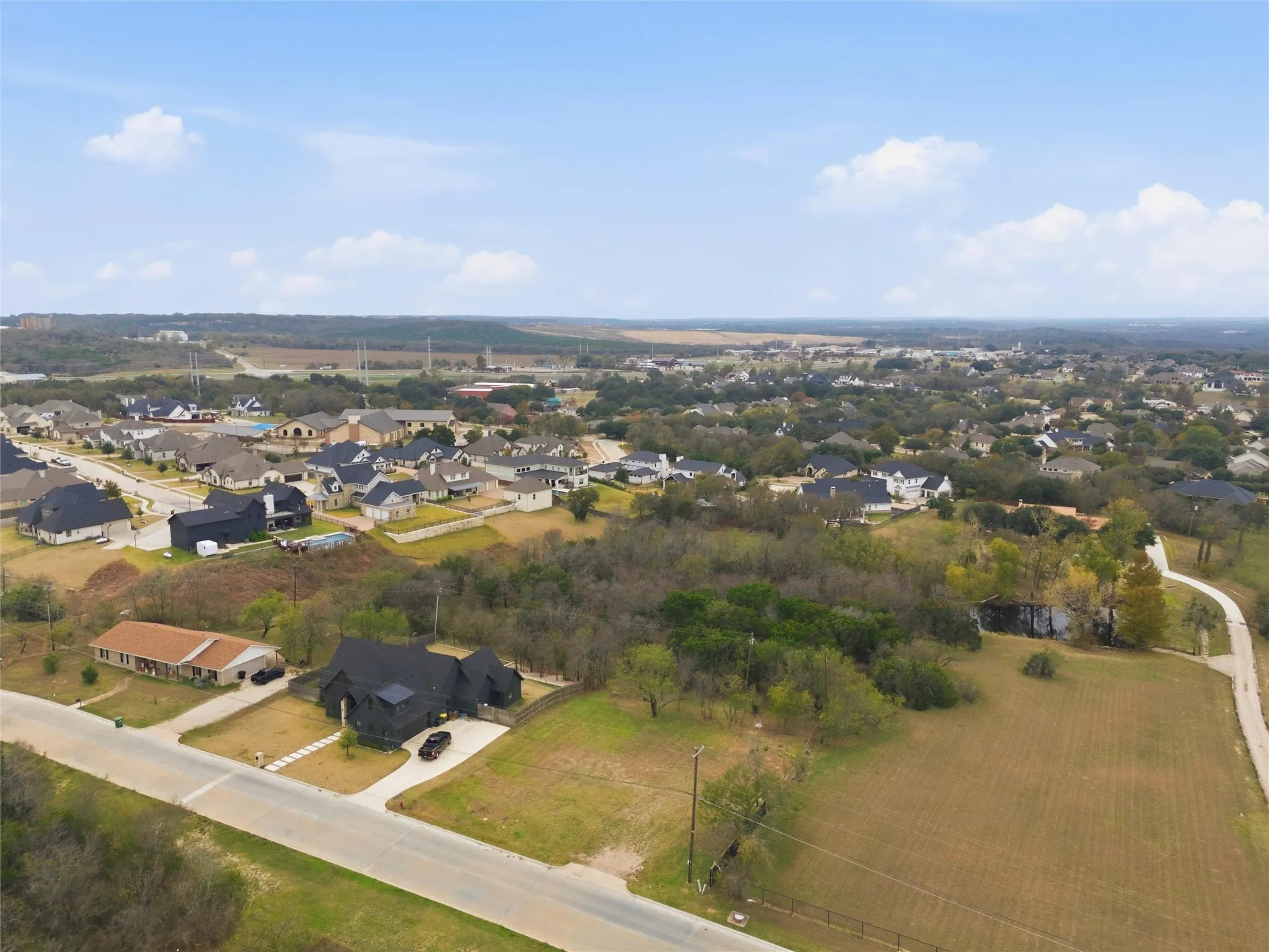 Aerial view of property and surrounding area with nearby suburban area