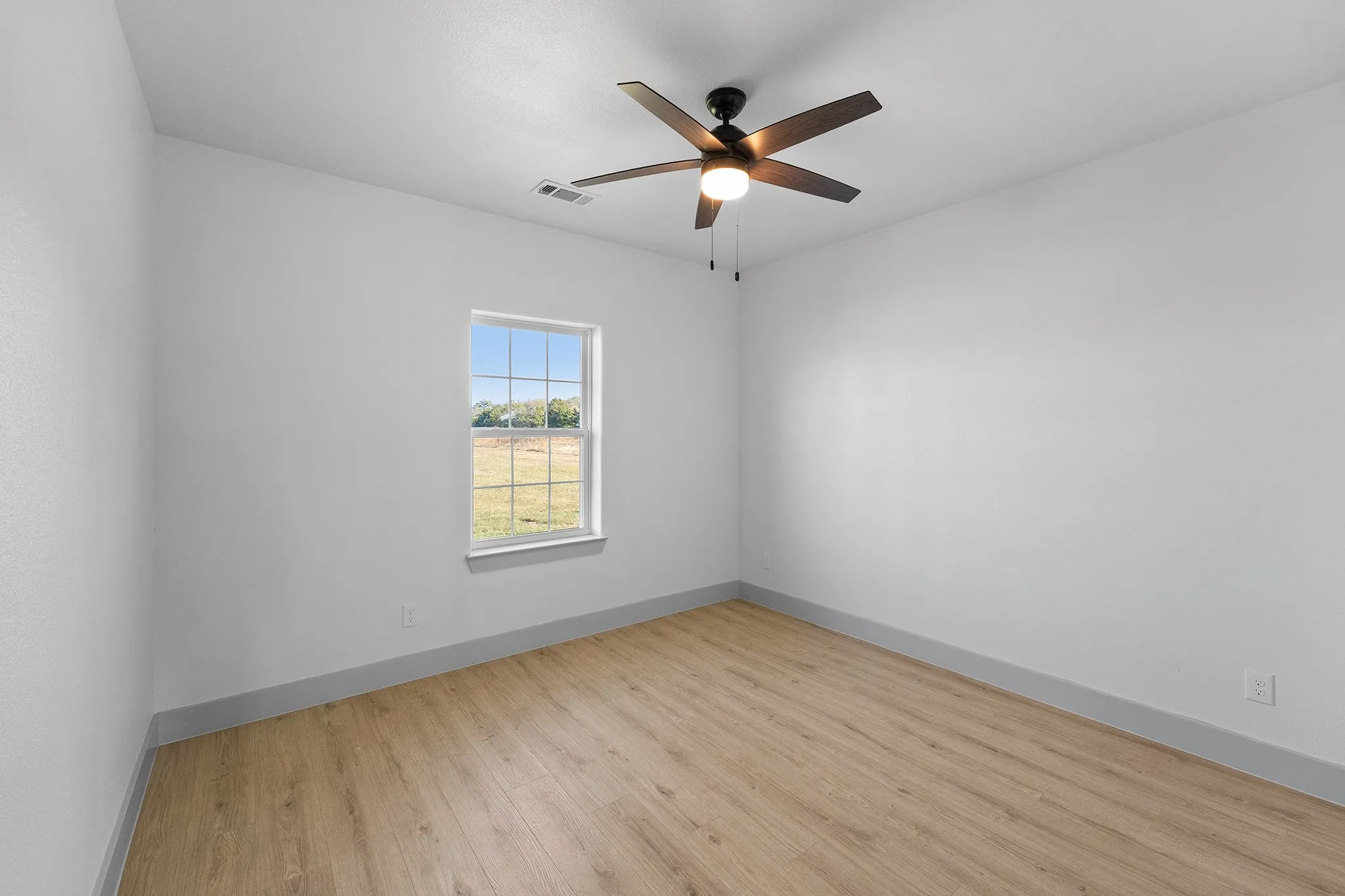 Unfurnished room featuring light wood-style floors and ceiling fan