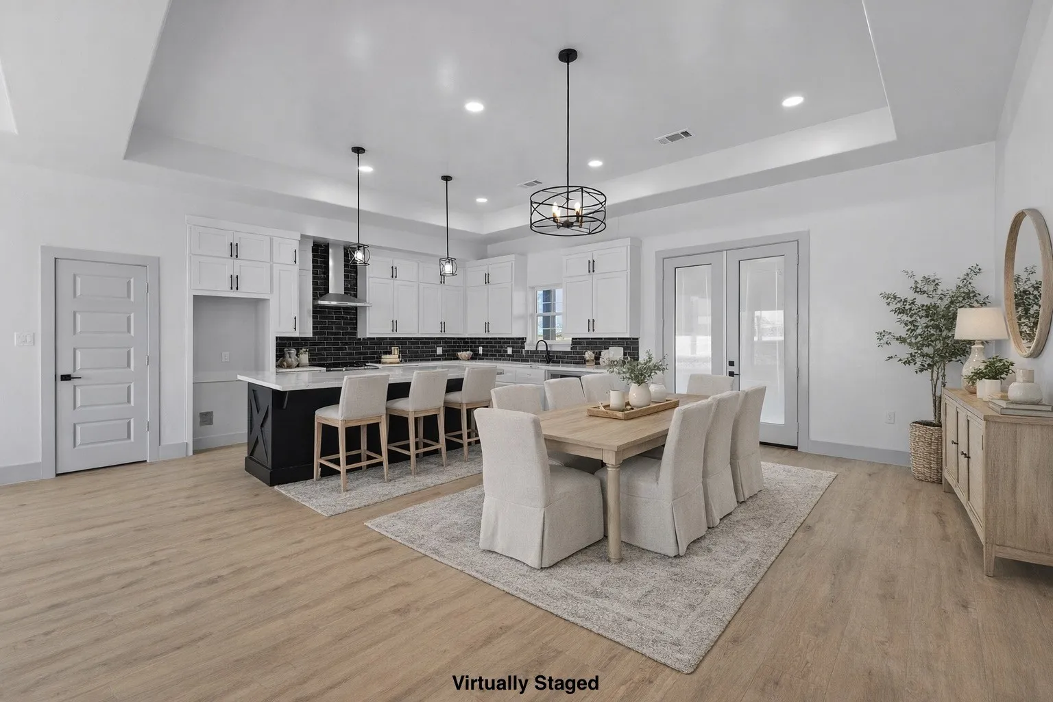 Dining room with a tray ceiling, light wood-style flooring, french doors, and recessed lighting