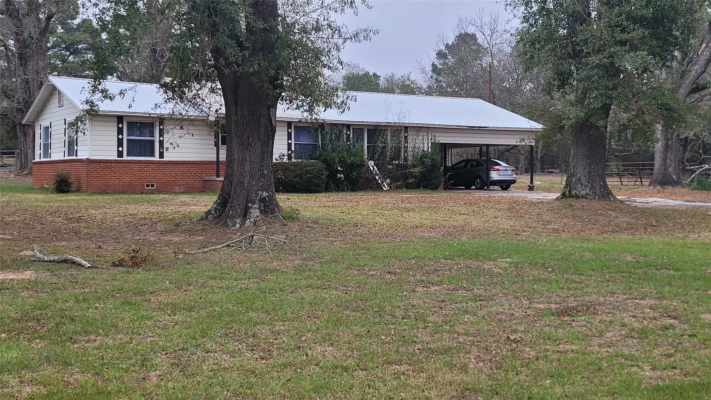 Ranch-style home with a metal roof, a front lawn, crawl space, and brick siding