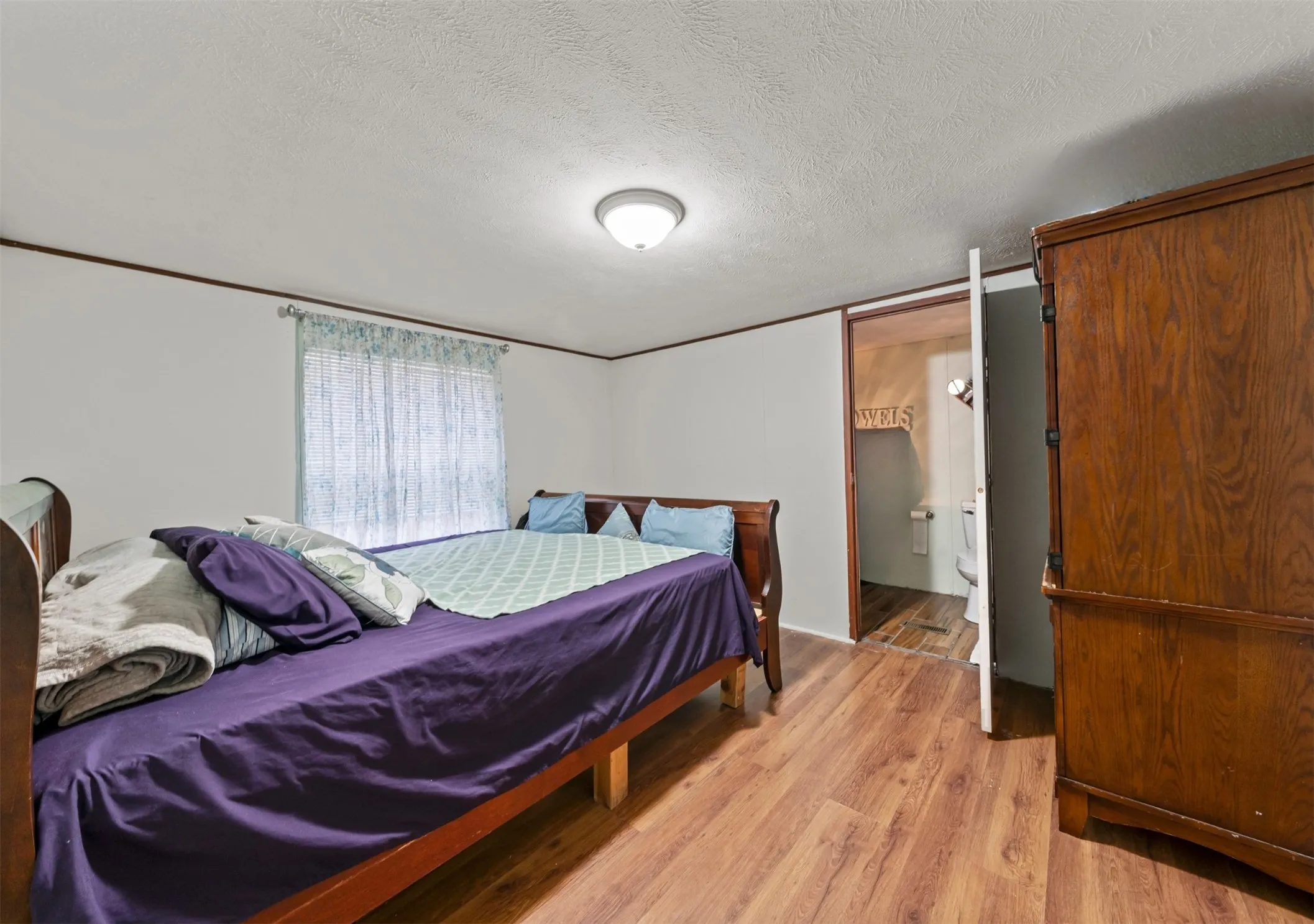 Bedroom featuring a textured ceiling and light wood finished floors