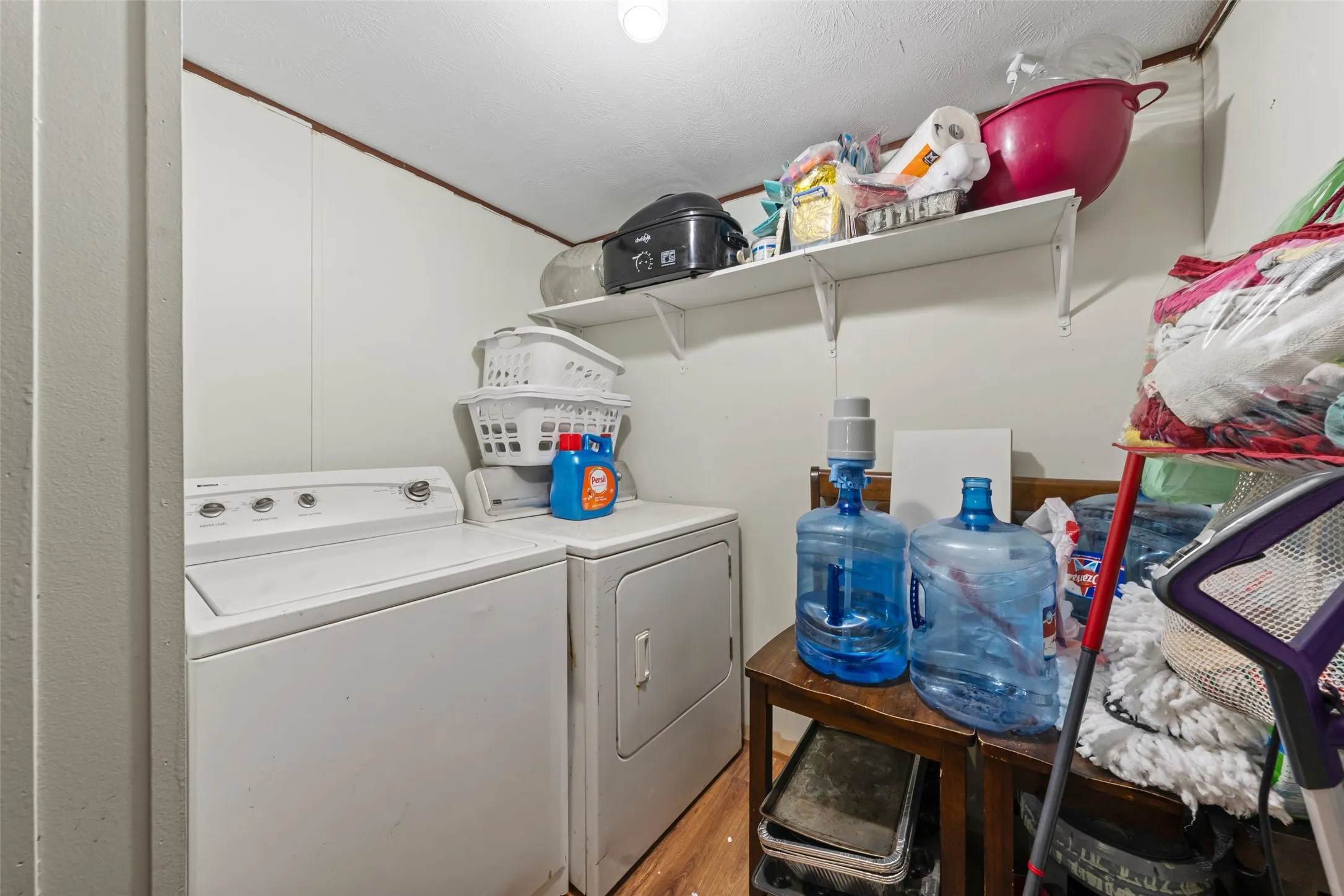 Laundry area with washing machine and clothes dryer and light wood-style floors