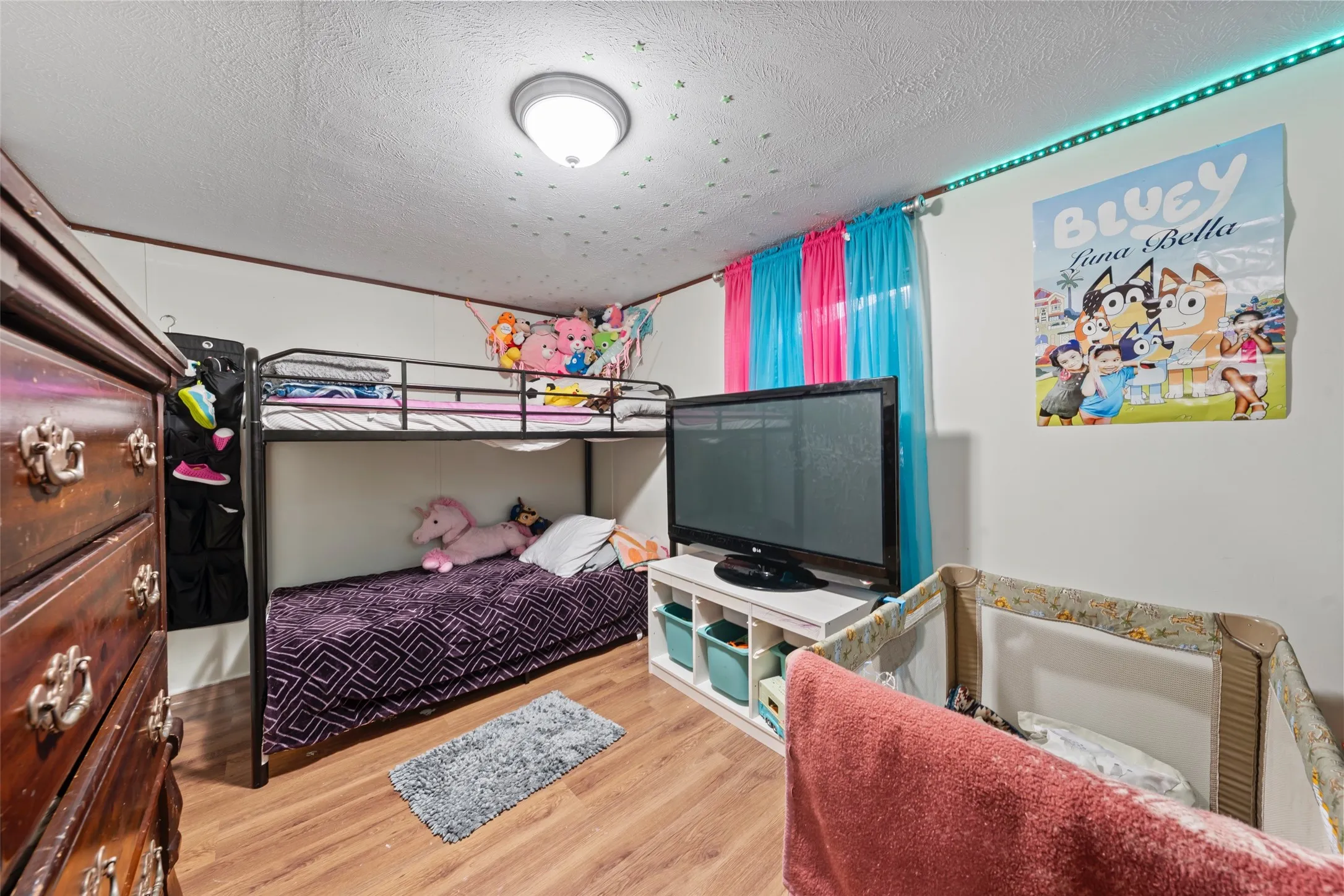 Bedroom with a textured ceiling and wood finished floors