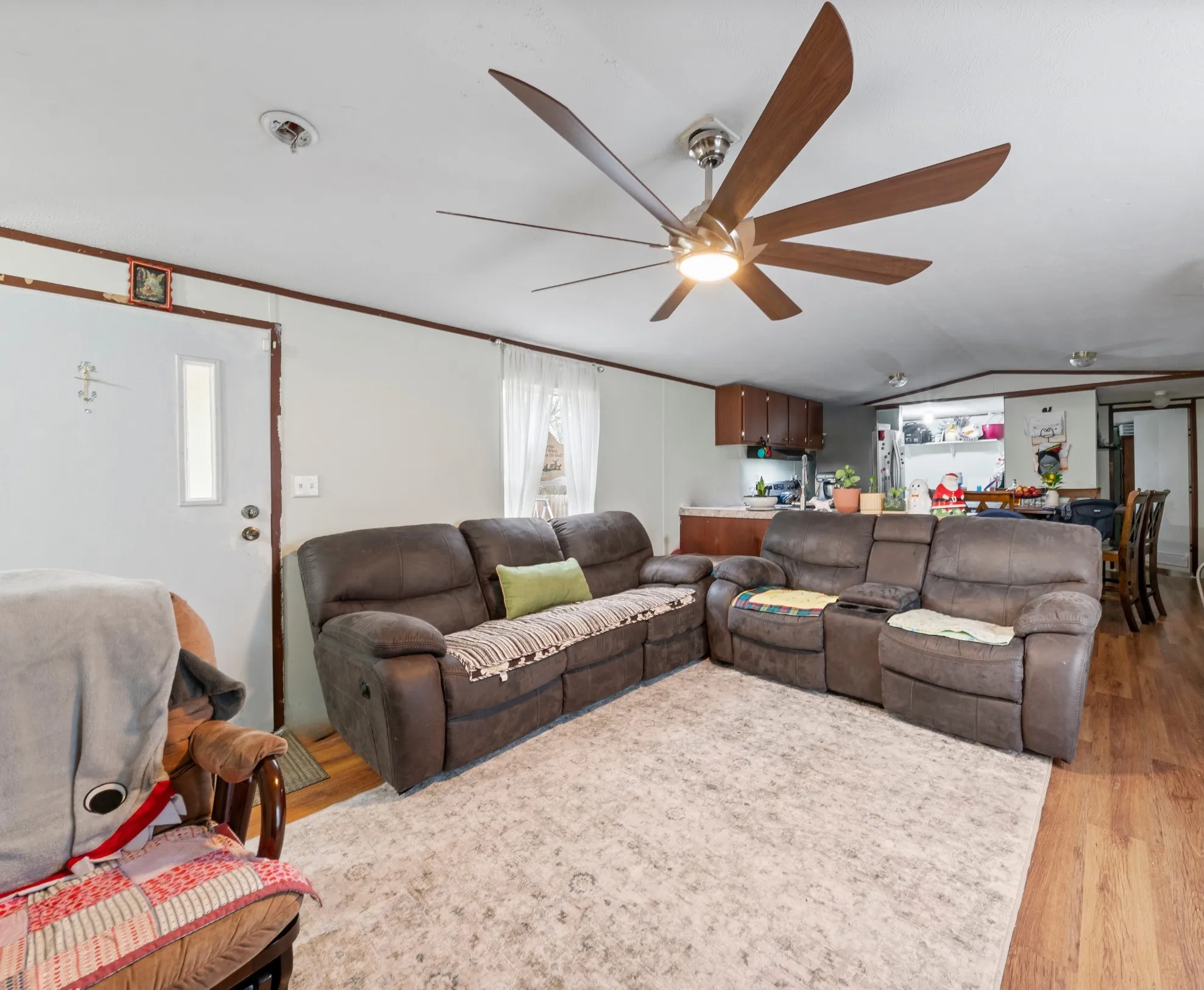 Living area with light wood finished floors, lofted ceiling, and ceiling fan