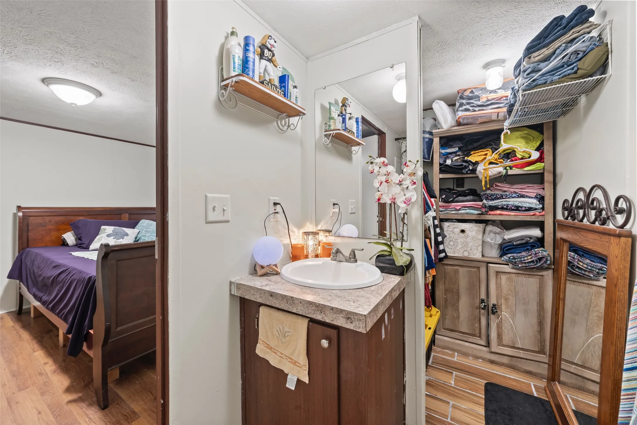 Bathroom featuring a textured ceiling, vanity, light wood-style floors, and ensuite bathroom