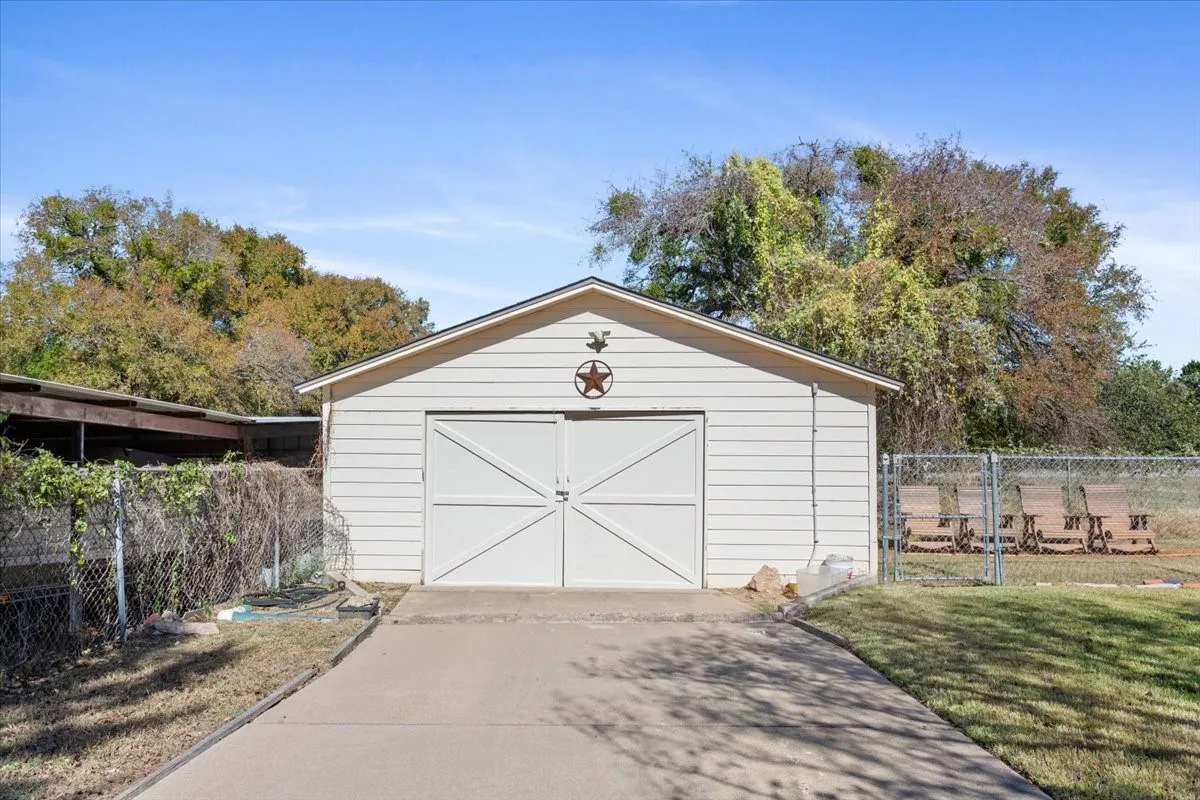Detached garage with concrete driveway and a gate