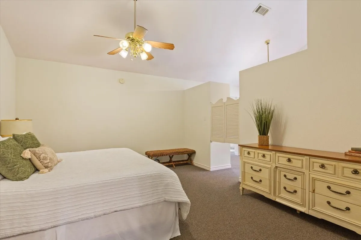 Bedroom featuring dark carpet, a ceiling fan, and lofted ceiling