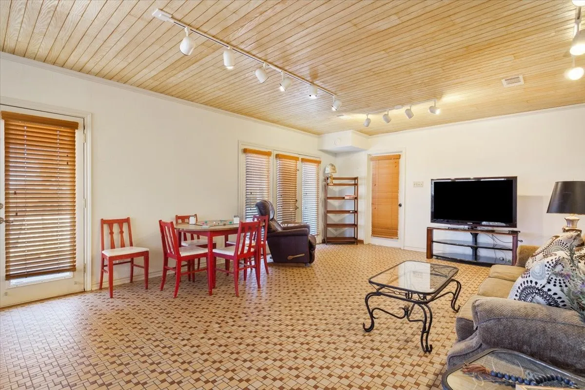 Living area featuring wooden ceiling, rail lighting, and crown molding