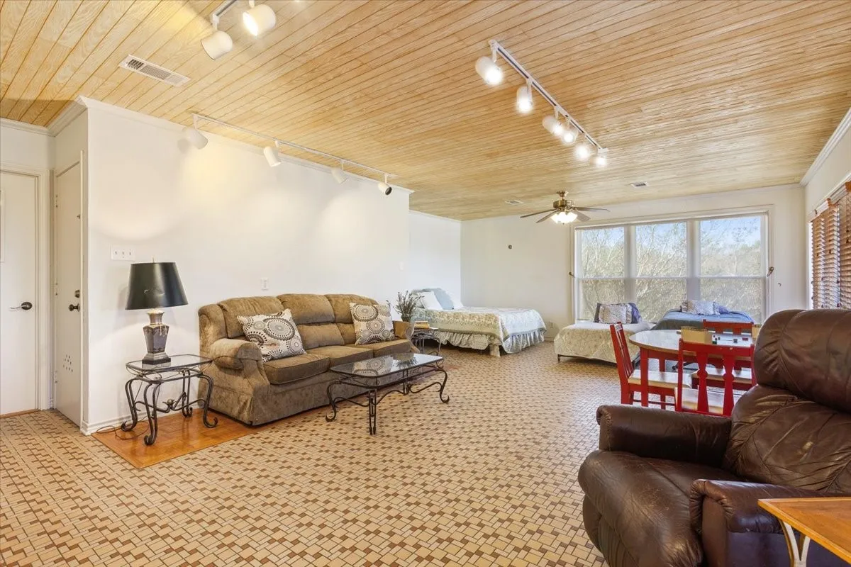 Living room featuring track lighting, wood ceiling, a ceiling fan, and ornamental molding