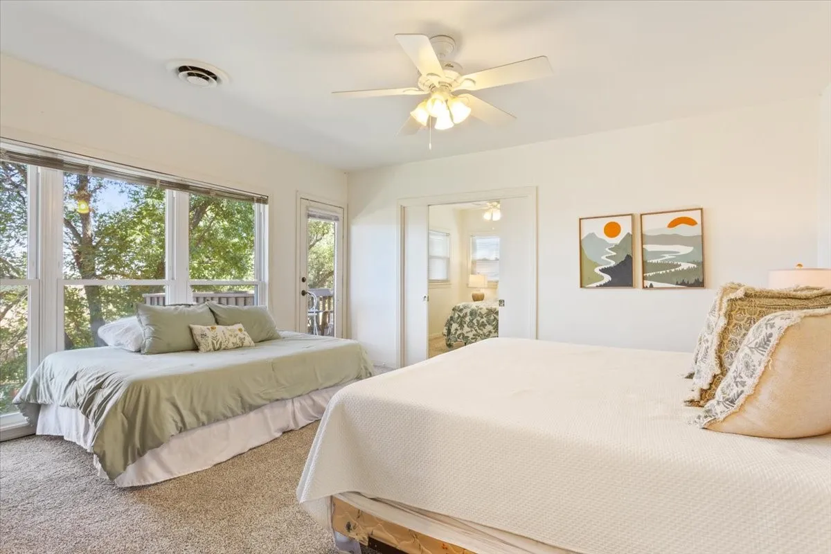 Carpeted bedroom featuring ceiling fan