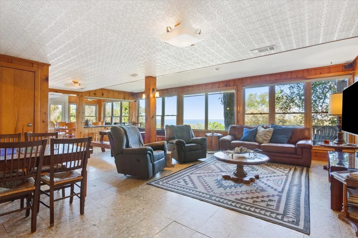 Living area with wood walls, an ornate ceiling, and light floors