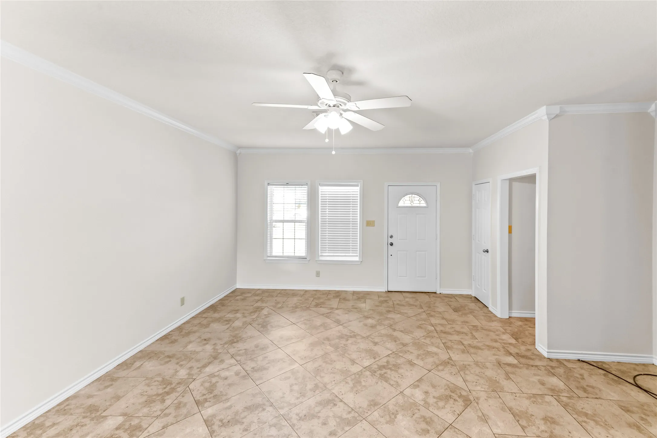Entrance foyer featuring crown molding, a ceiling fan, and light tile patterned floors