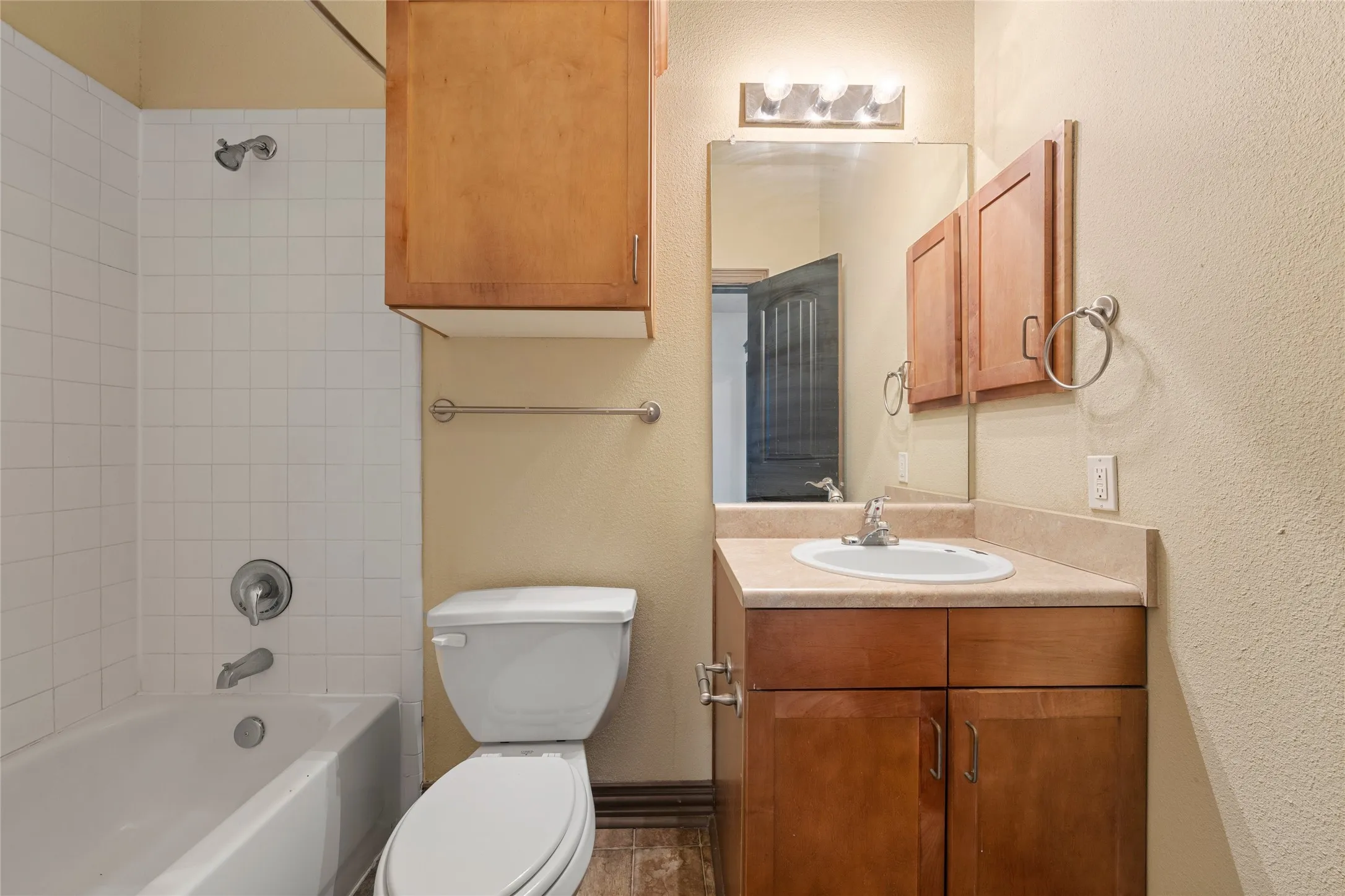Bathroom featuring vanity, shower / bathtub combination, and a textured wall
