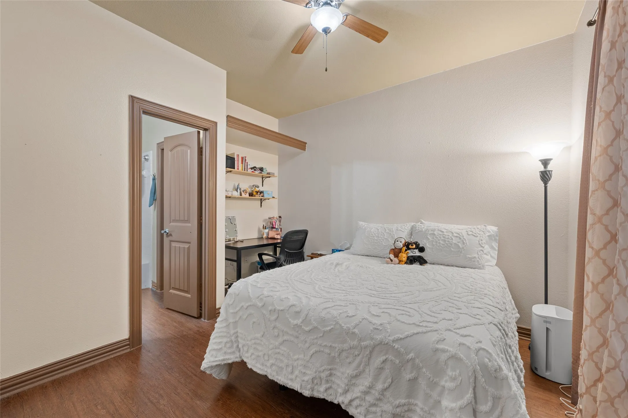Bedroom with a desk, wood finished floors, and a ceiling fan
