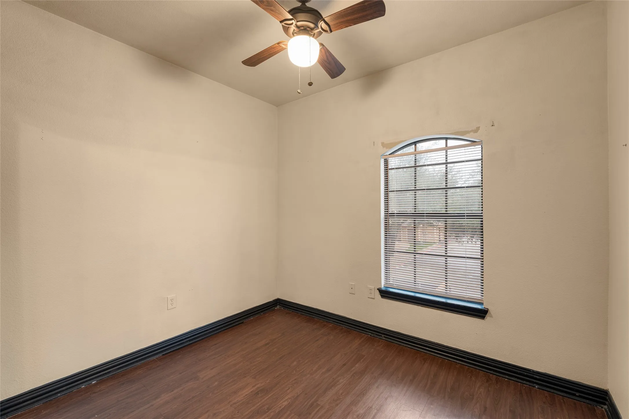 Spare room featuring dark wood finished floors and ceiling fan