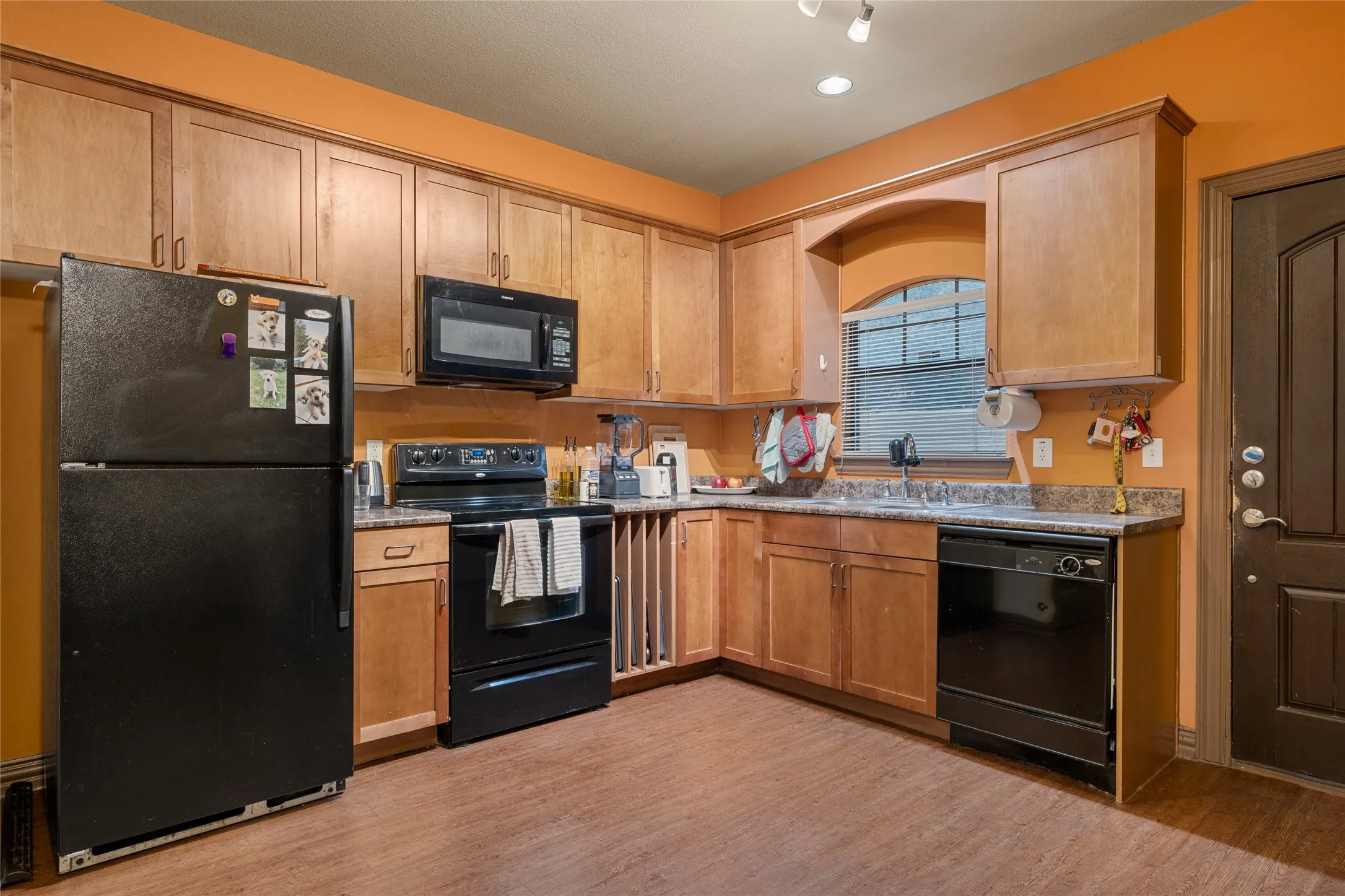Kitchen featuring black appliances, light wood finished floors, and recessed lighting