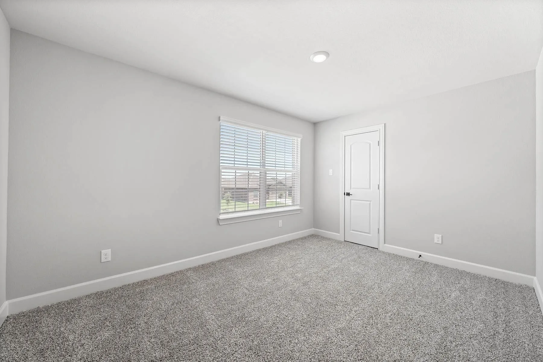 Carpeted spare room featuring baseboards