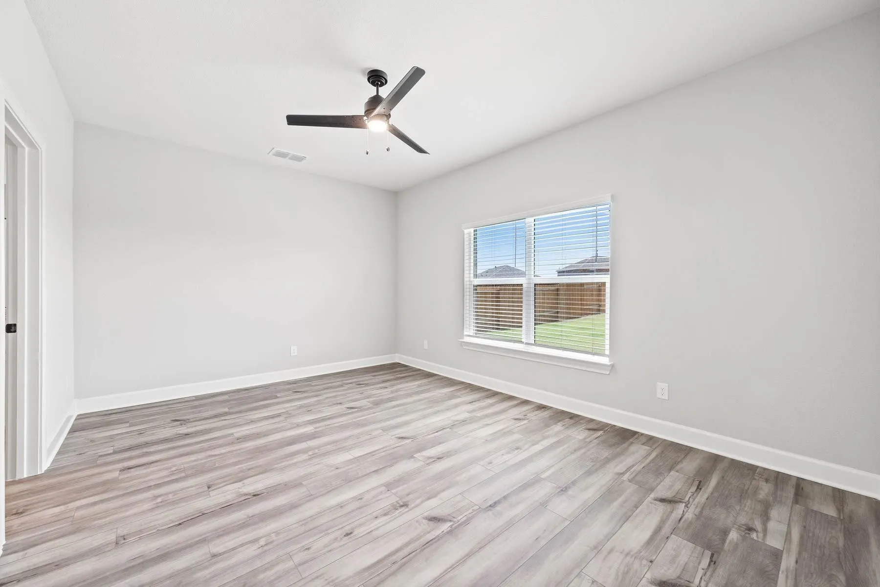 Spare room with light wood-type flooring and a ceiling fan