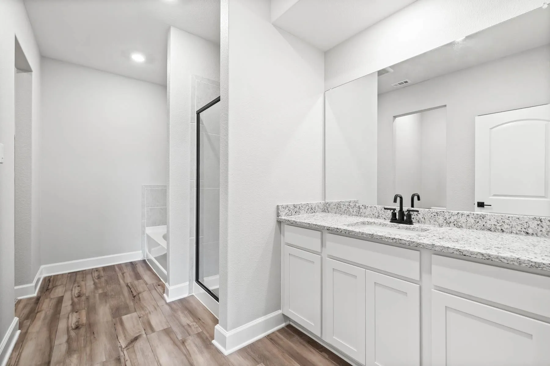 Full bath with light wood-style floors, vanity, a shower stall, a tub to relax in, and recessed lighting