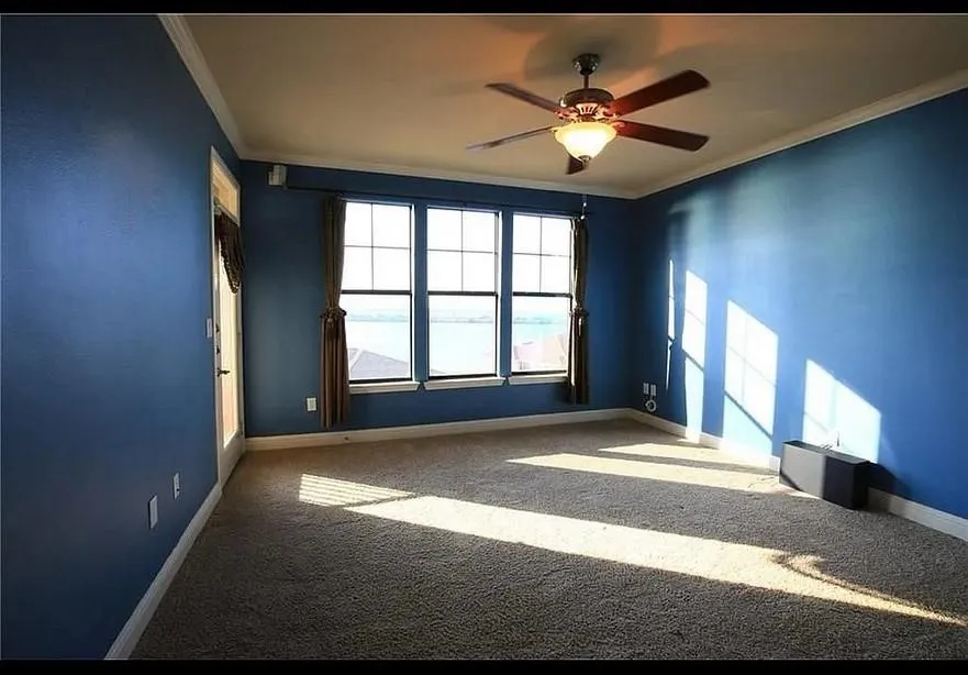 Carpeted empty room featuring ornamental molding and a ceiling fan