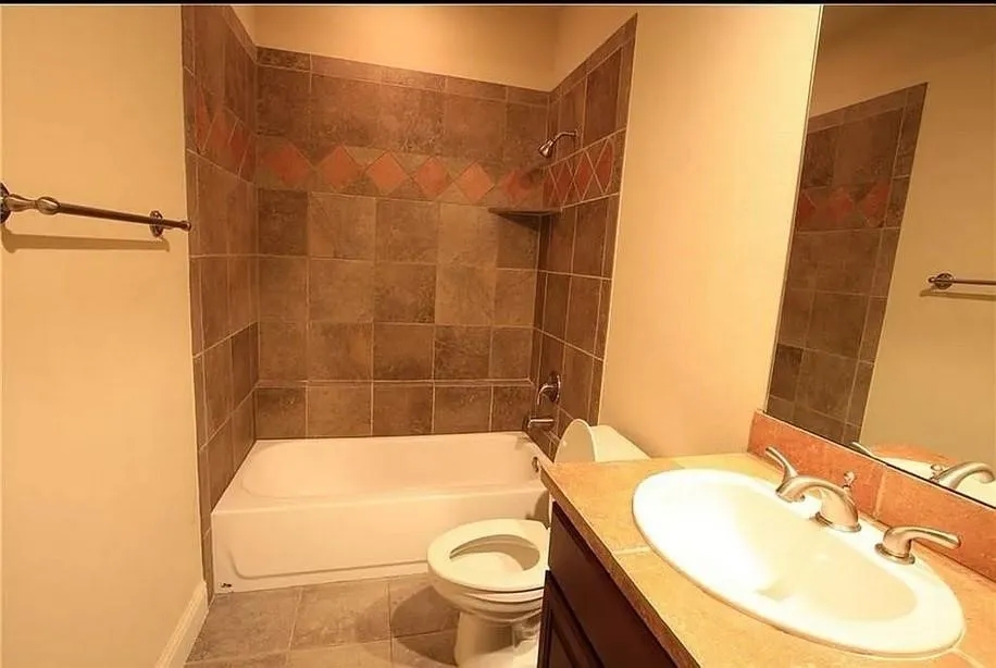 Full bathroom featuring washtub / shower combination, vanity, and light tile patterned floors