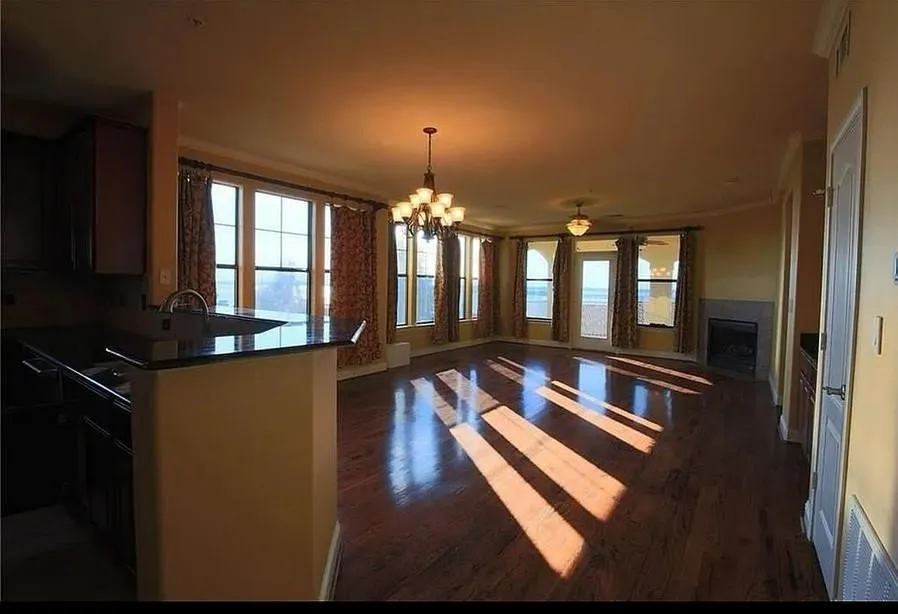 Kitchen featuring a chandelier, ornamental molding, pendant lighting, dark wood-style floors, and healthy amount of natural light