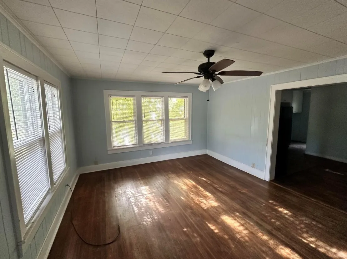 Spare room with dark wood-style flooring and a ceiling fan