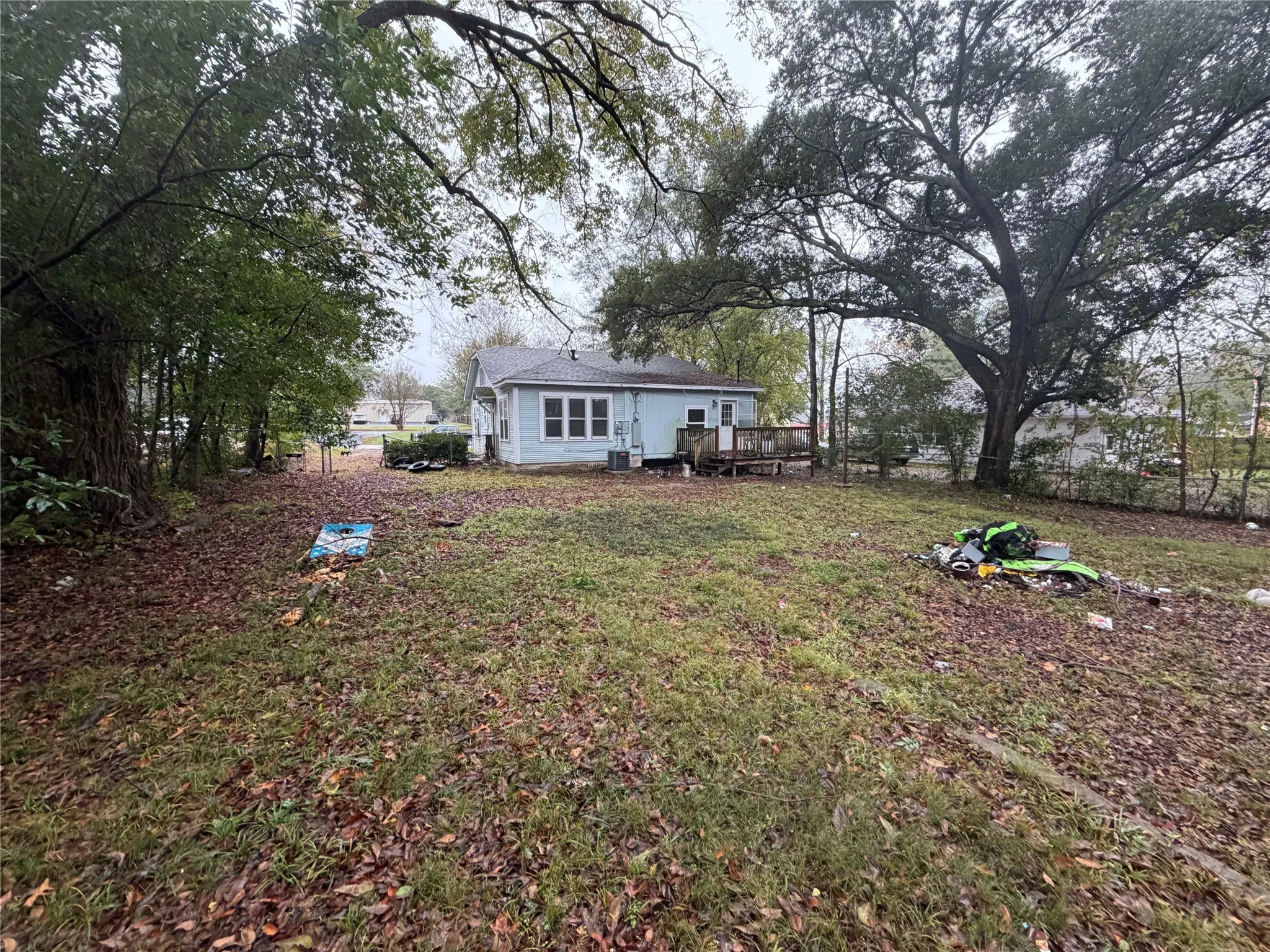 Rear view of house featuring a deck and a lawn