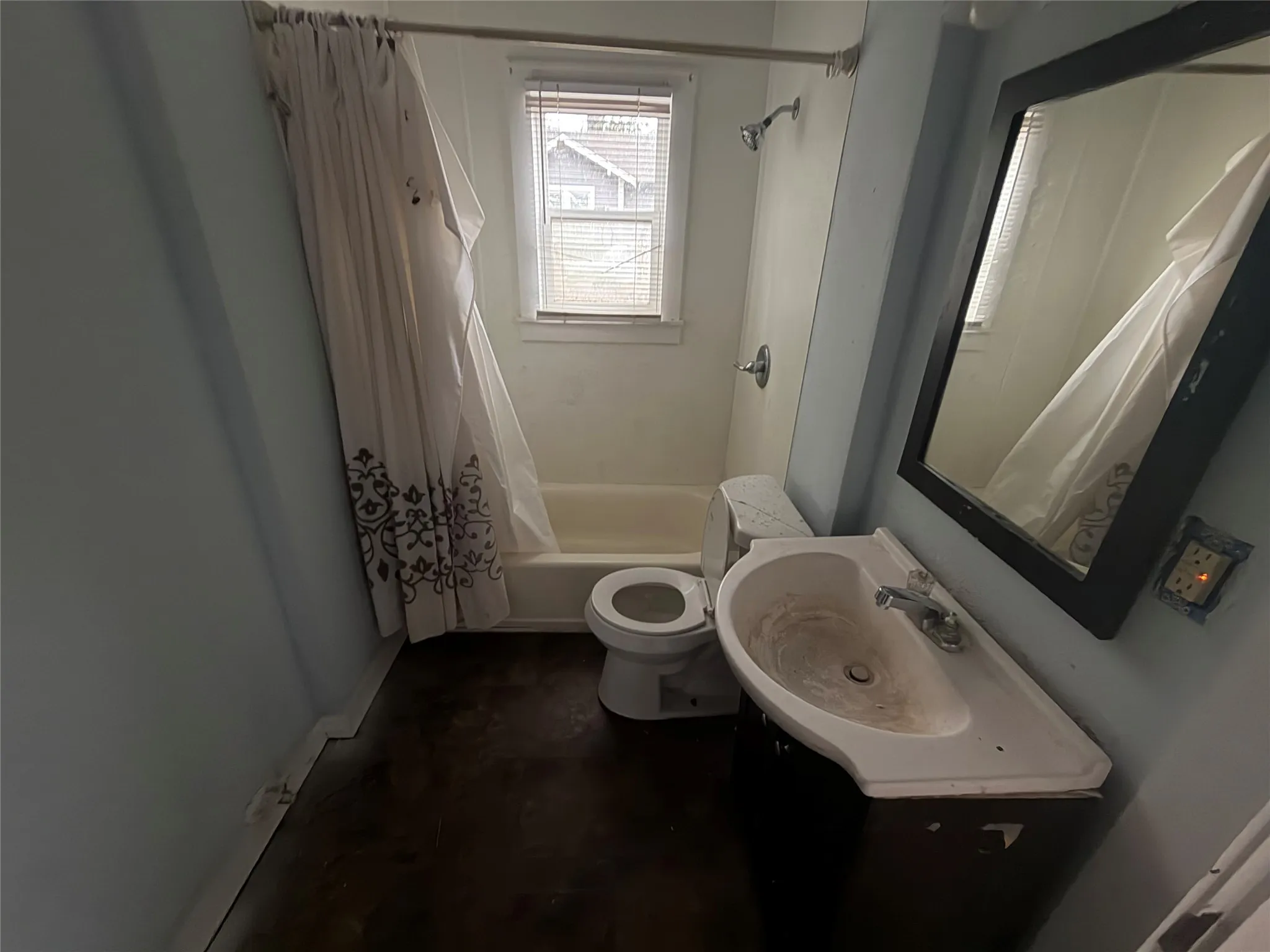Bathroom featuring shower / bathtub combination with curtain, vanity, and concrete floors