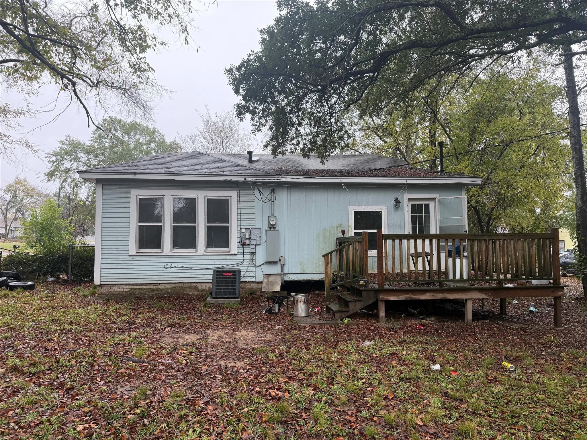 Rear view of house with a wooden deck and roof with shingles