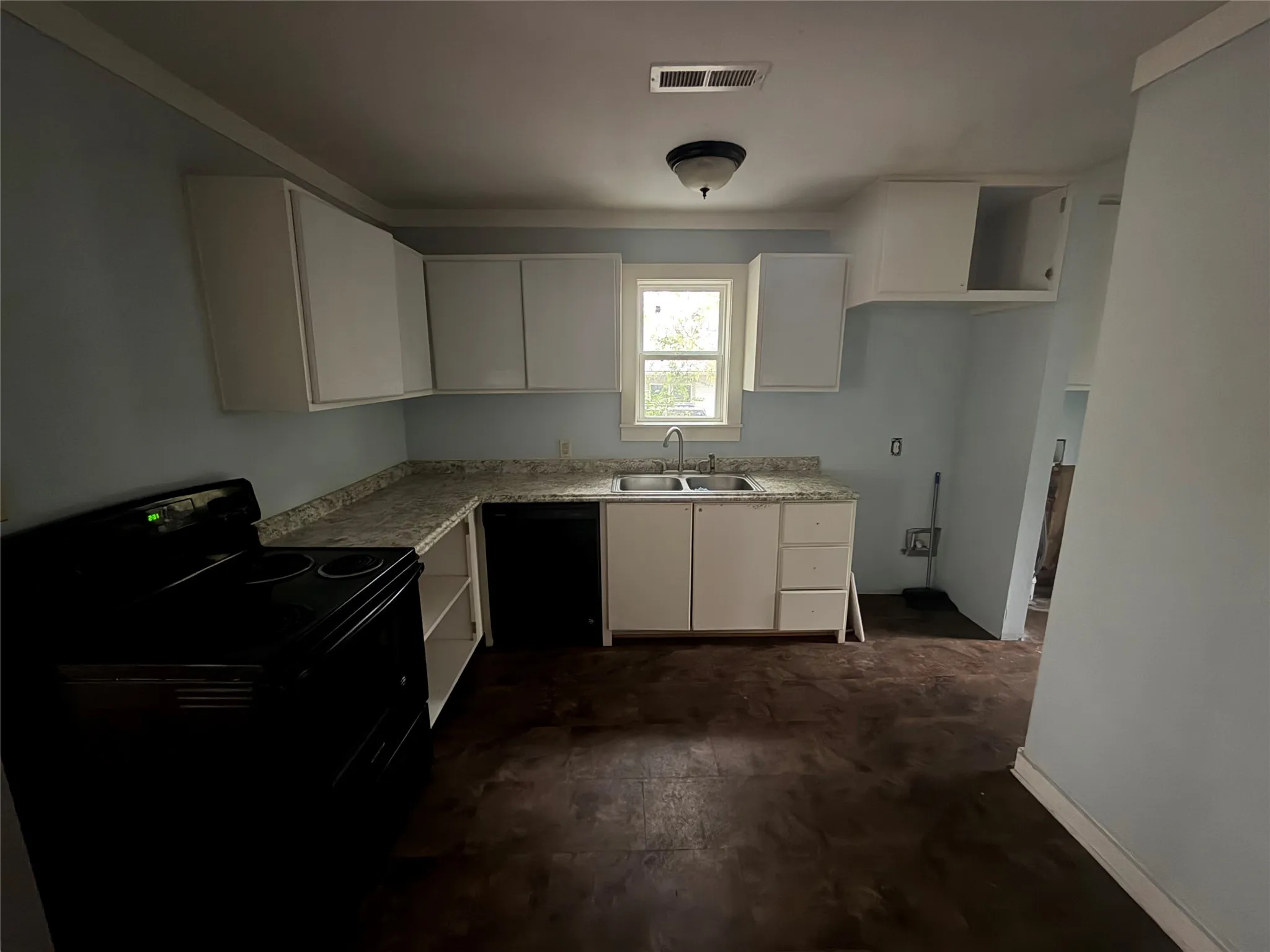 Kitchen with light countertops, white cabinetry, and black appliances