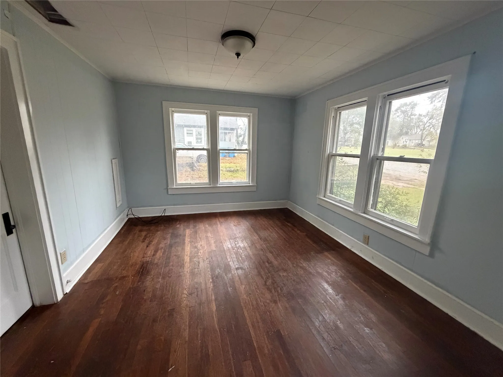 Spare room with dark wood-type flooring and ornamental molding