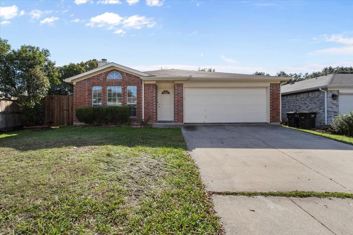 Single story home with concrete driveway, brick siding, and a garage