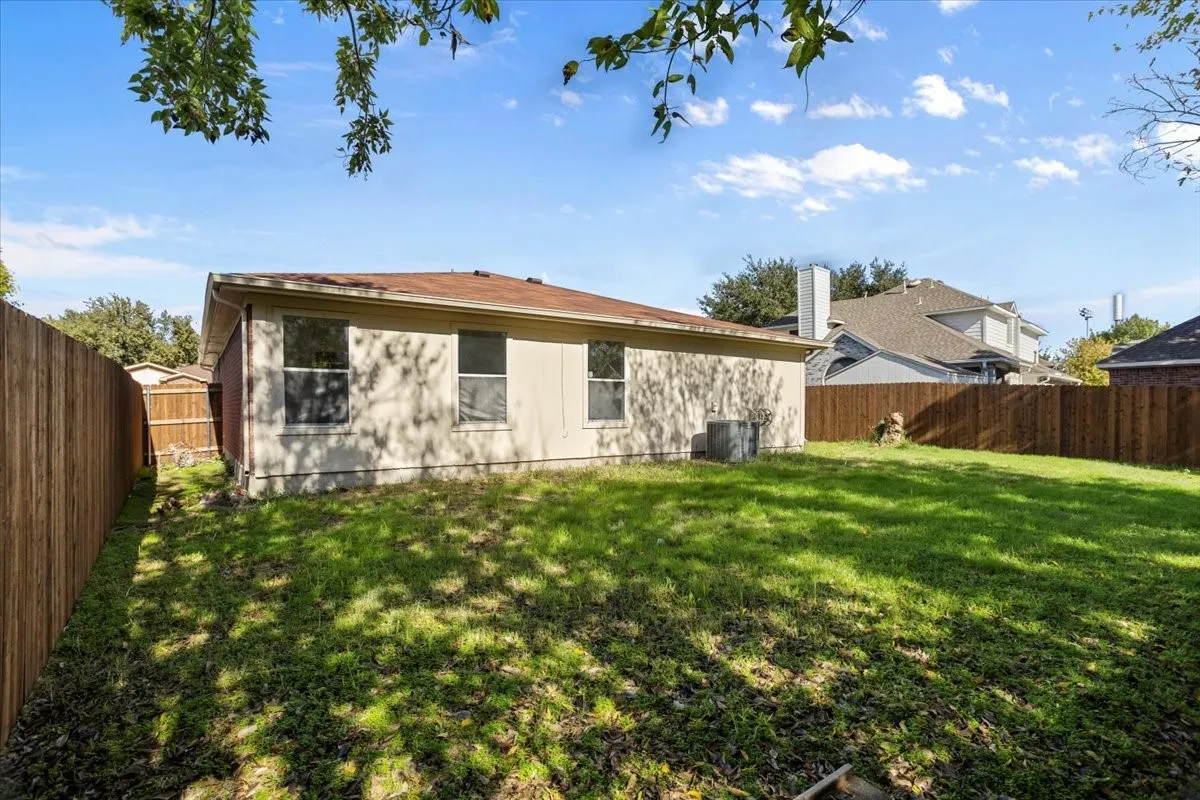Rear view of house with a fenced backyard