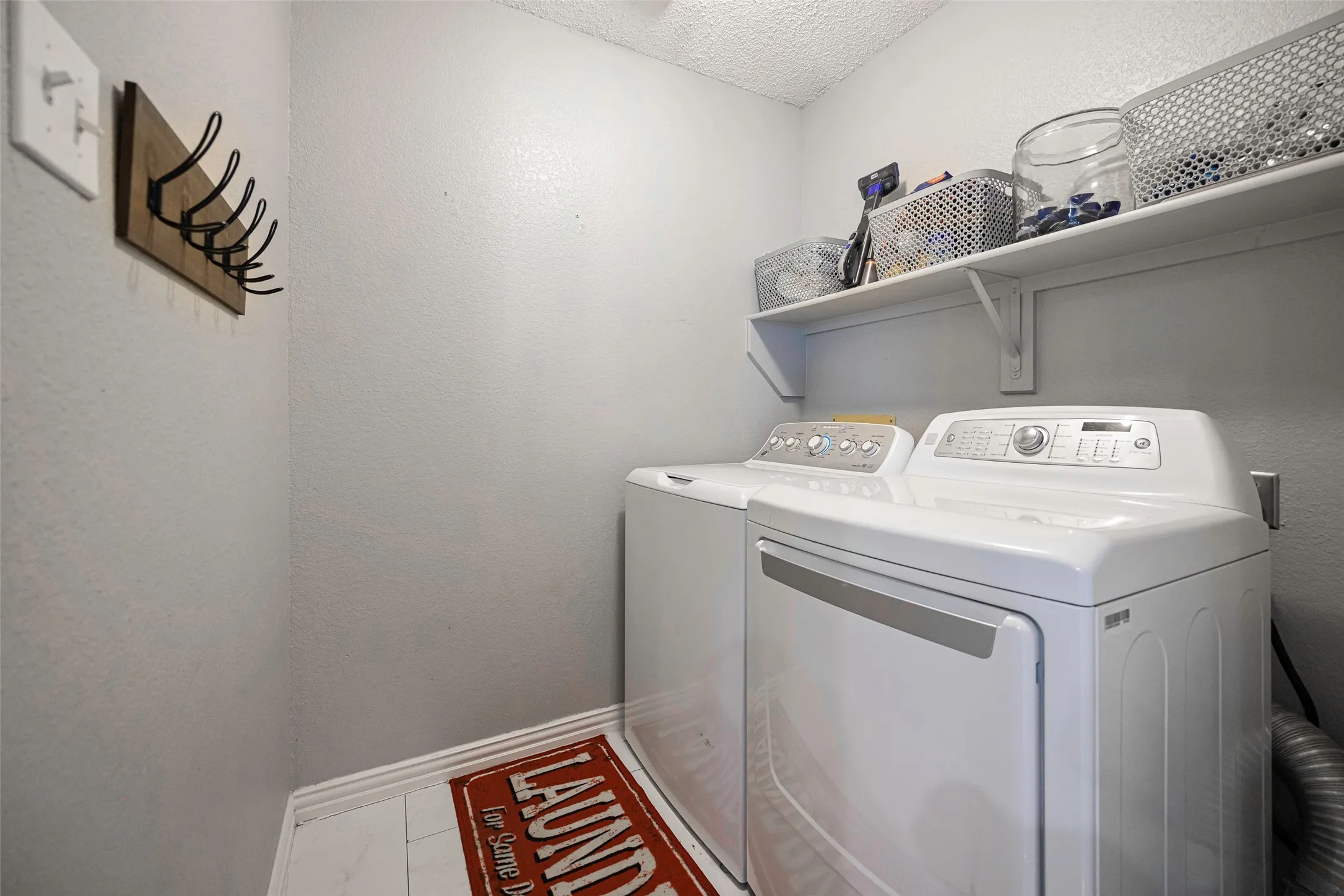 Full size washer and dryer area that leads to the 2 car garage