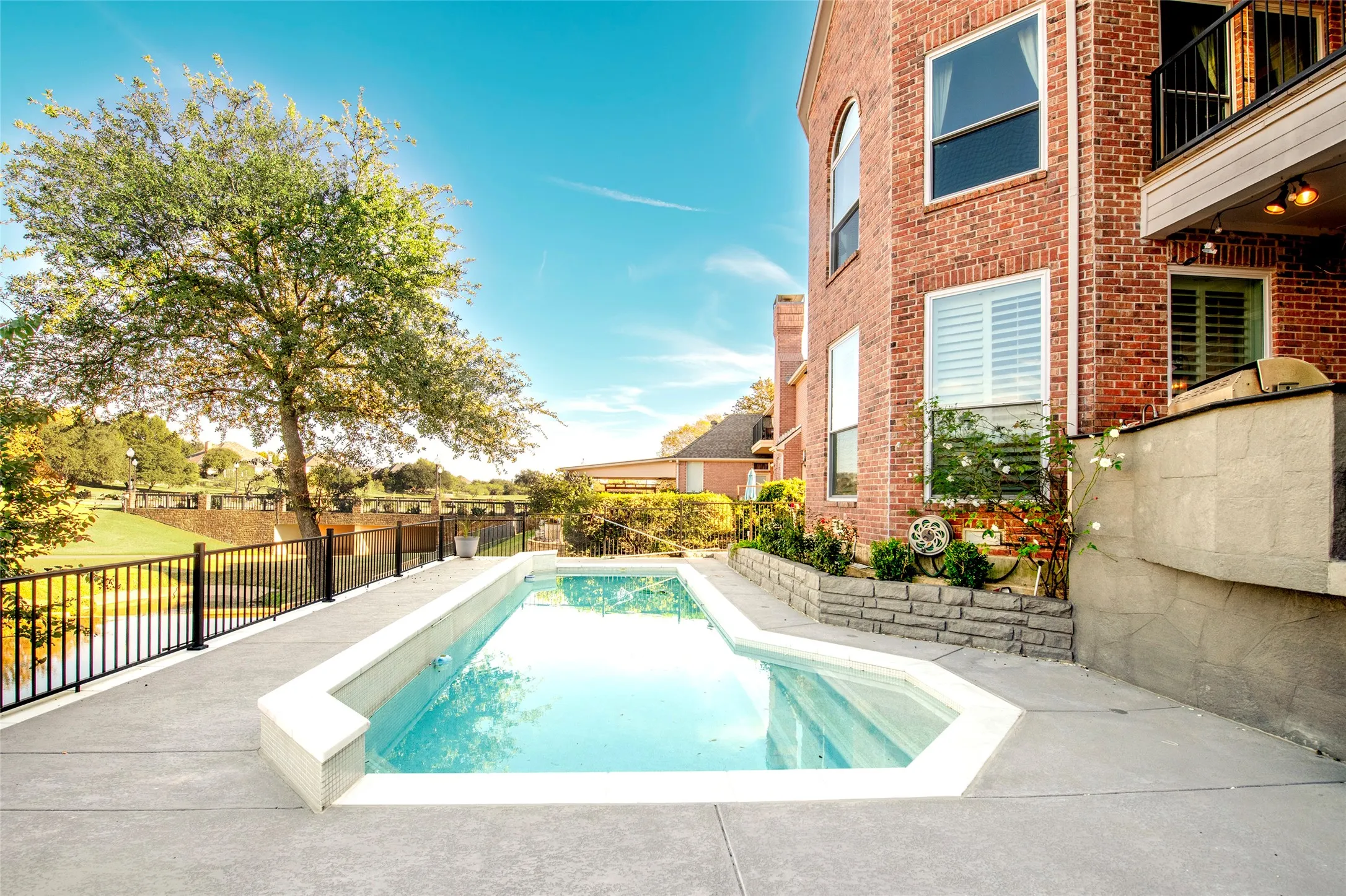 View of pool with a fenced backyard, a patio area, and a balcony