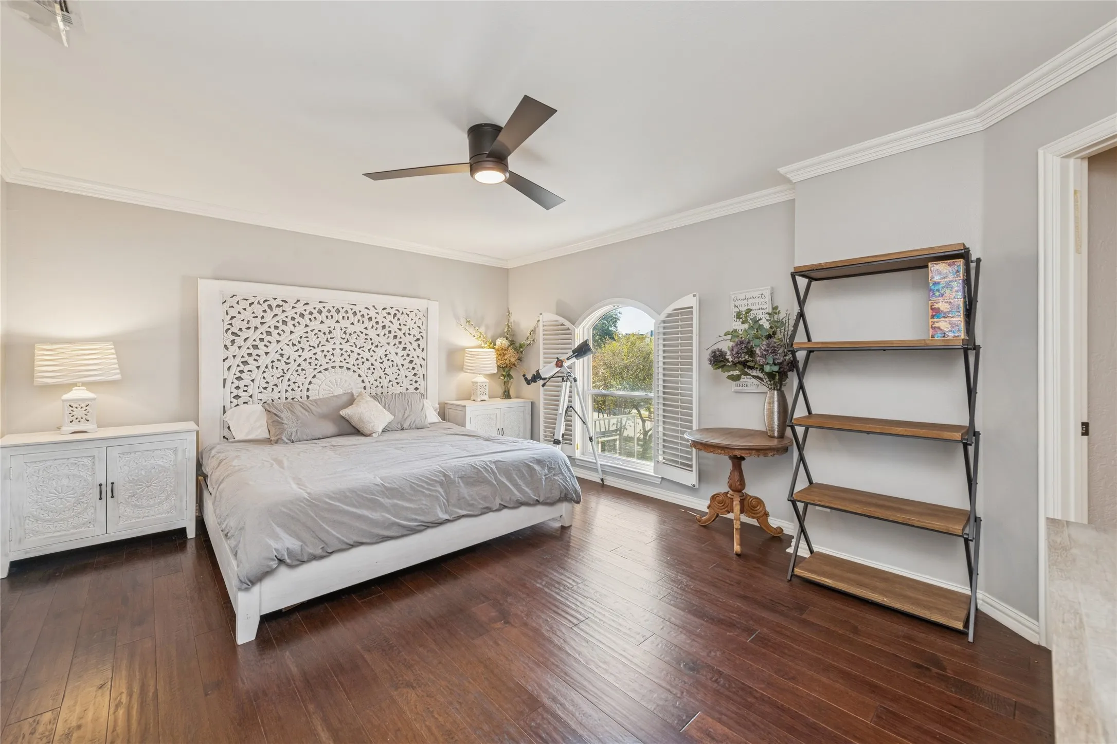 Bedroom featuring dark wood-type flooring, ornamental molding, and ceiling fan