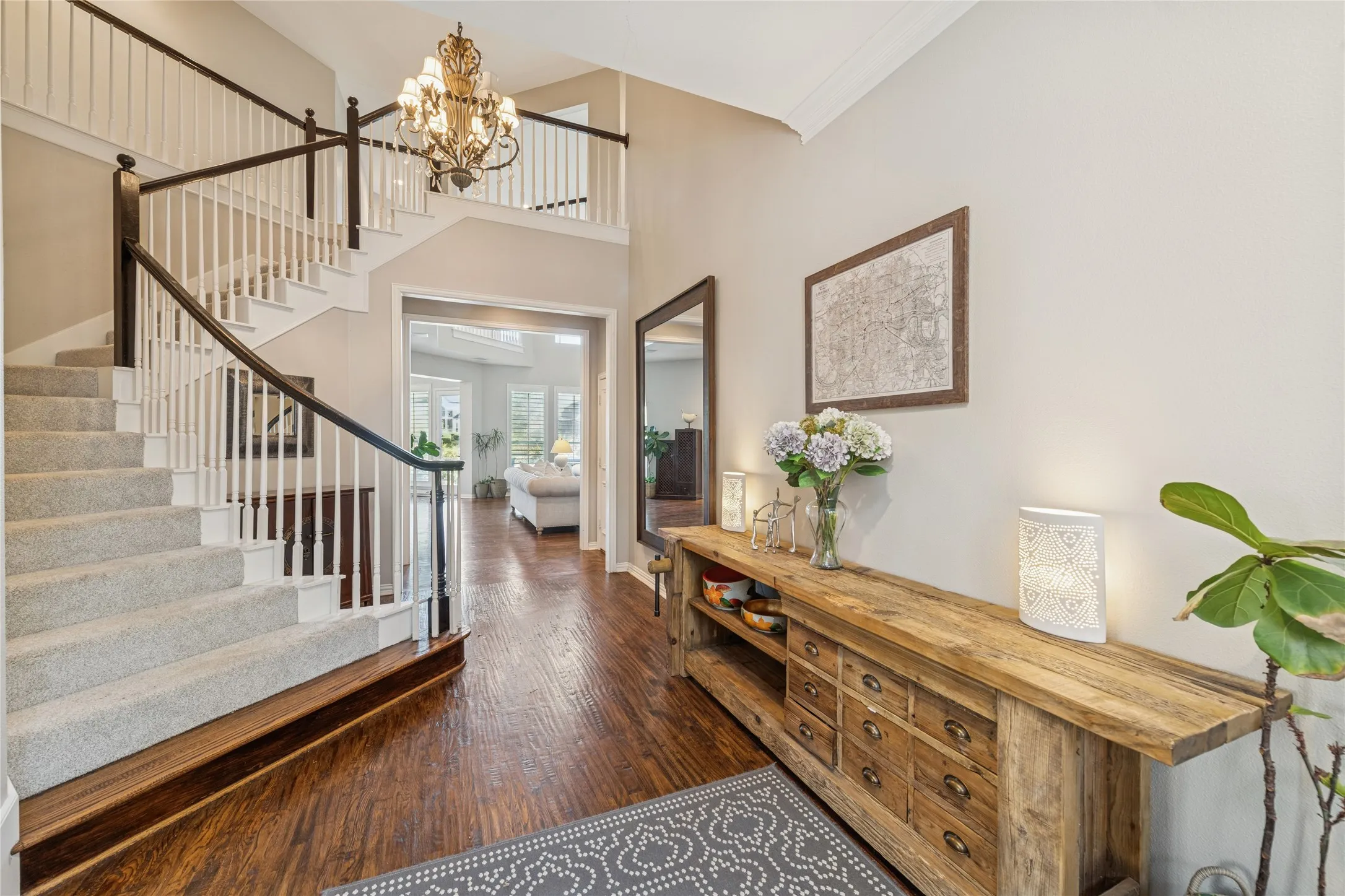 Entryway featuring a towering ceiling, stairs, dark wood-type flooring, and a chandelier