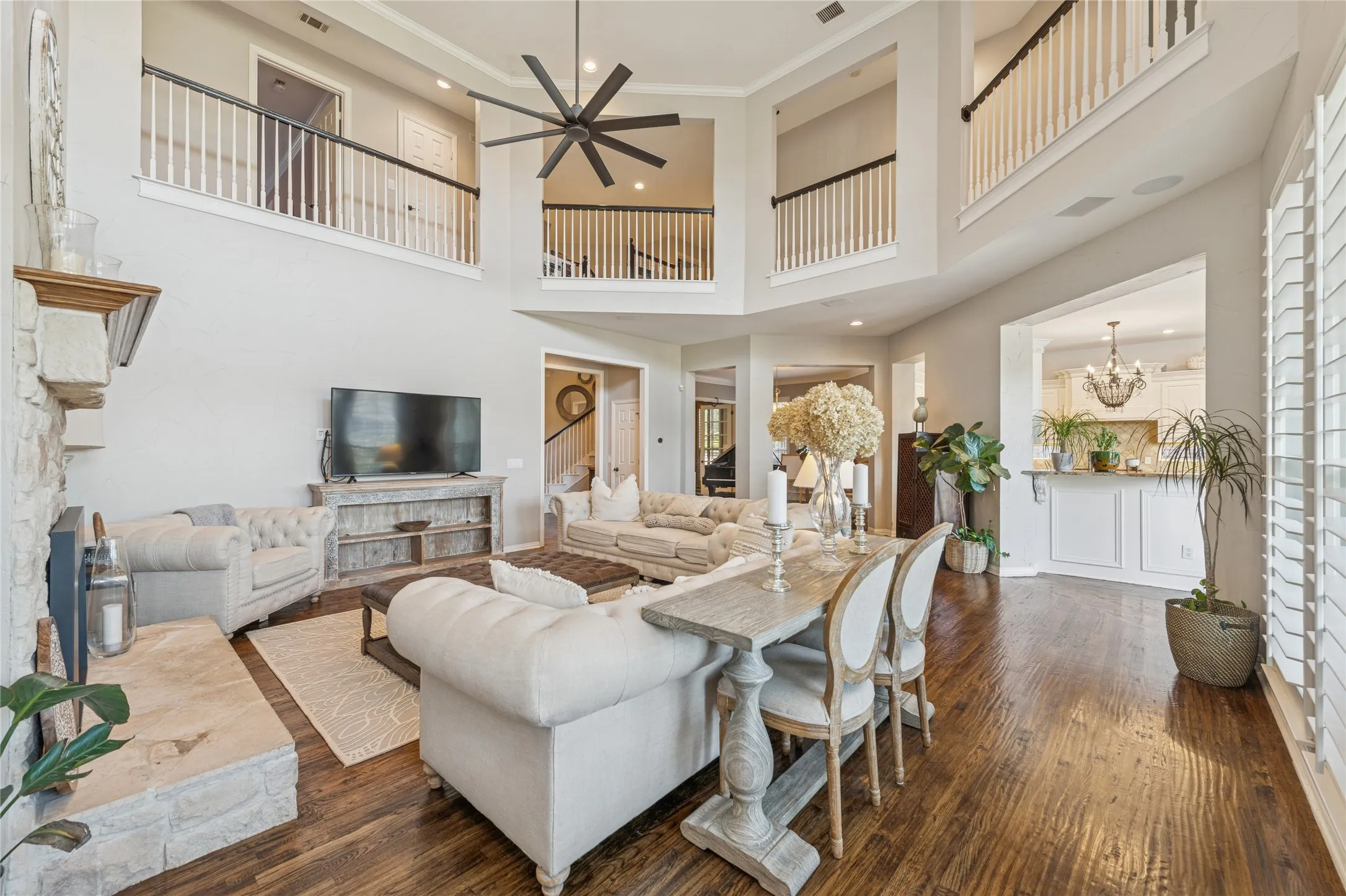 Living area with stairway, dark wood-style floors, ornamental molding, a towering ceiling, and a chandelier