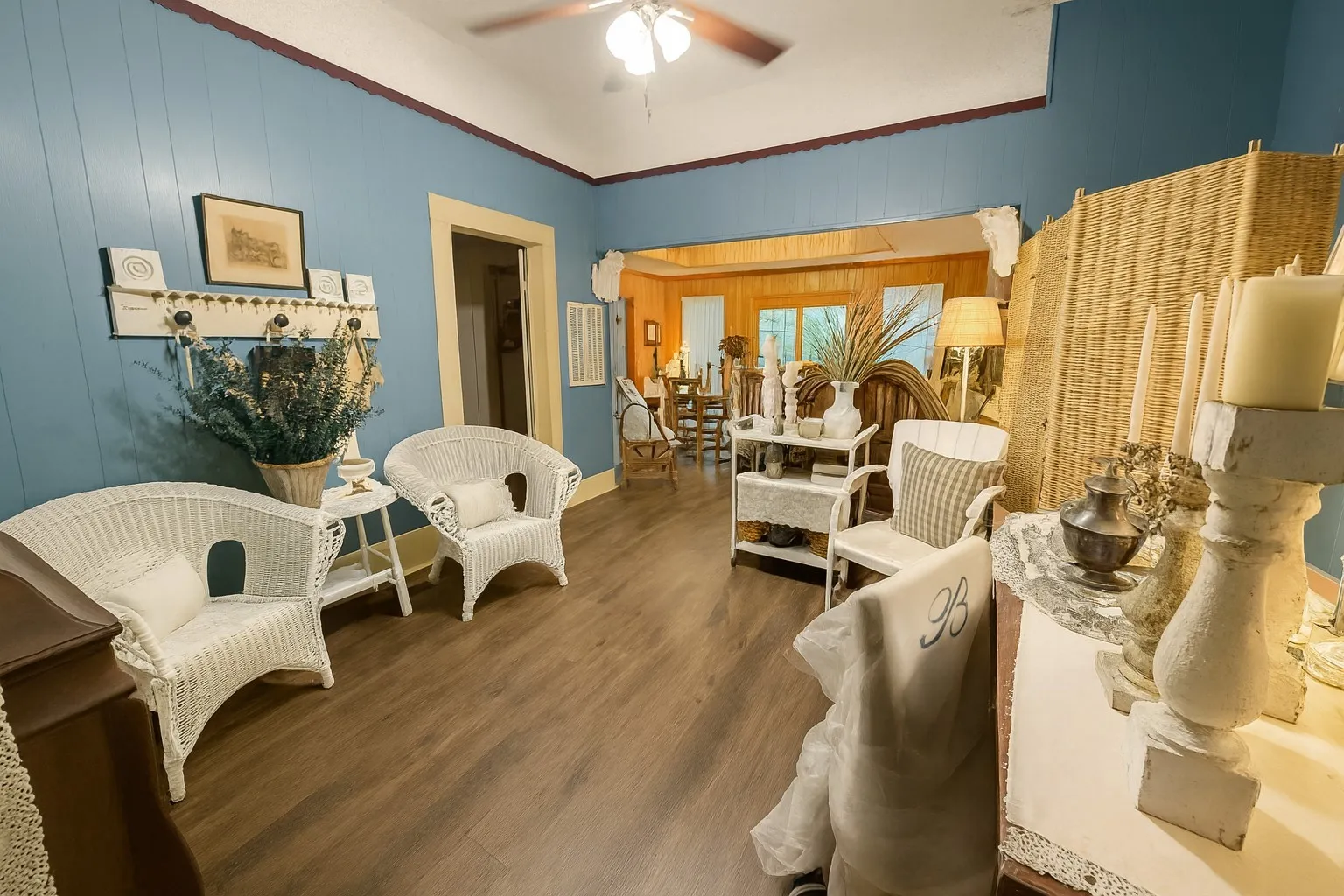 Sitting room featuring painted paneling walls, crown molding, dark wood-style floors, and ceiling fan