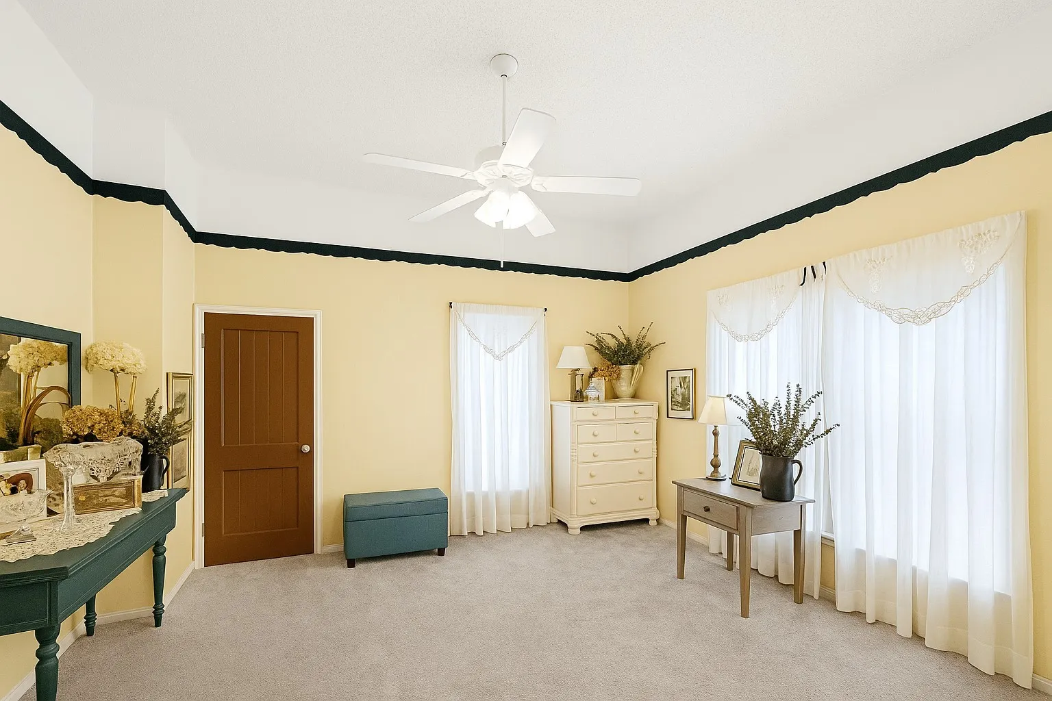 Carpeted bedroom featuring multiple windows and ceiling fan